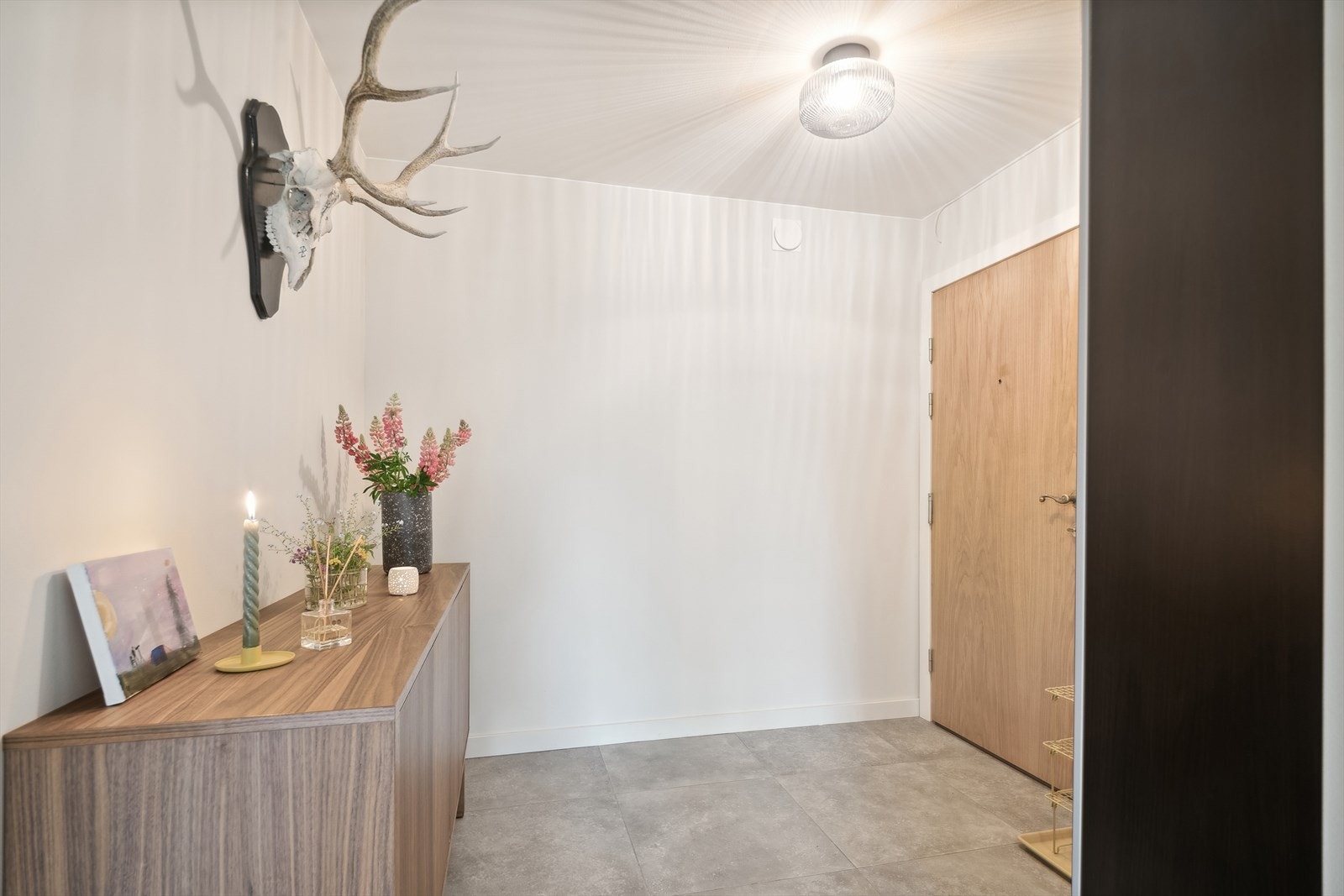 Entréen har malte veggflater og pene fliser med varmekabler på gulvet og god plass til innredning. Galleribilde