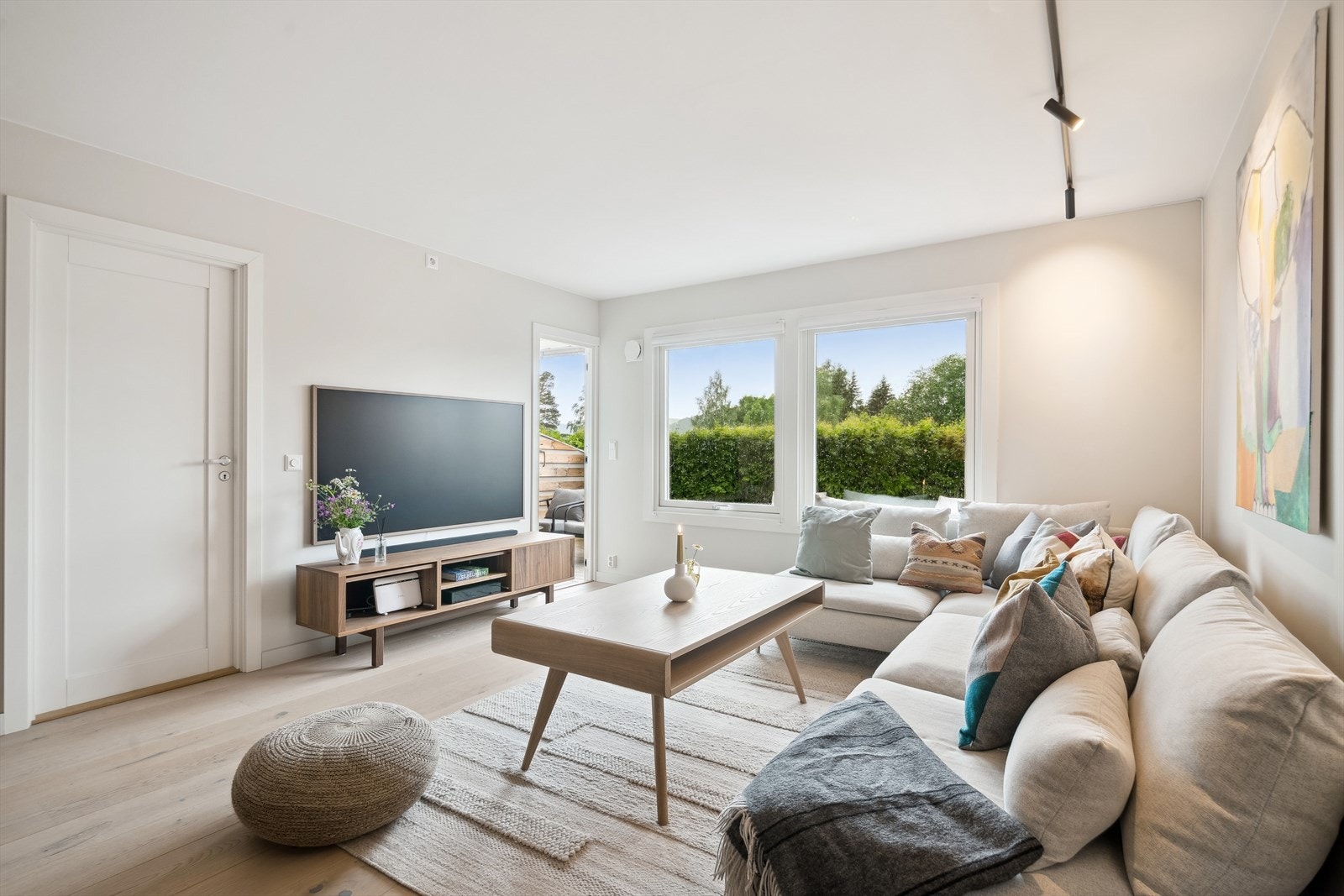 Stuen har store og nyere vinduer og balkongdør fra 2016. Det god plass til både tv og en stor sofa i stuen. Galleribilde