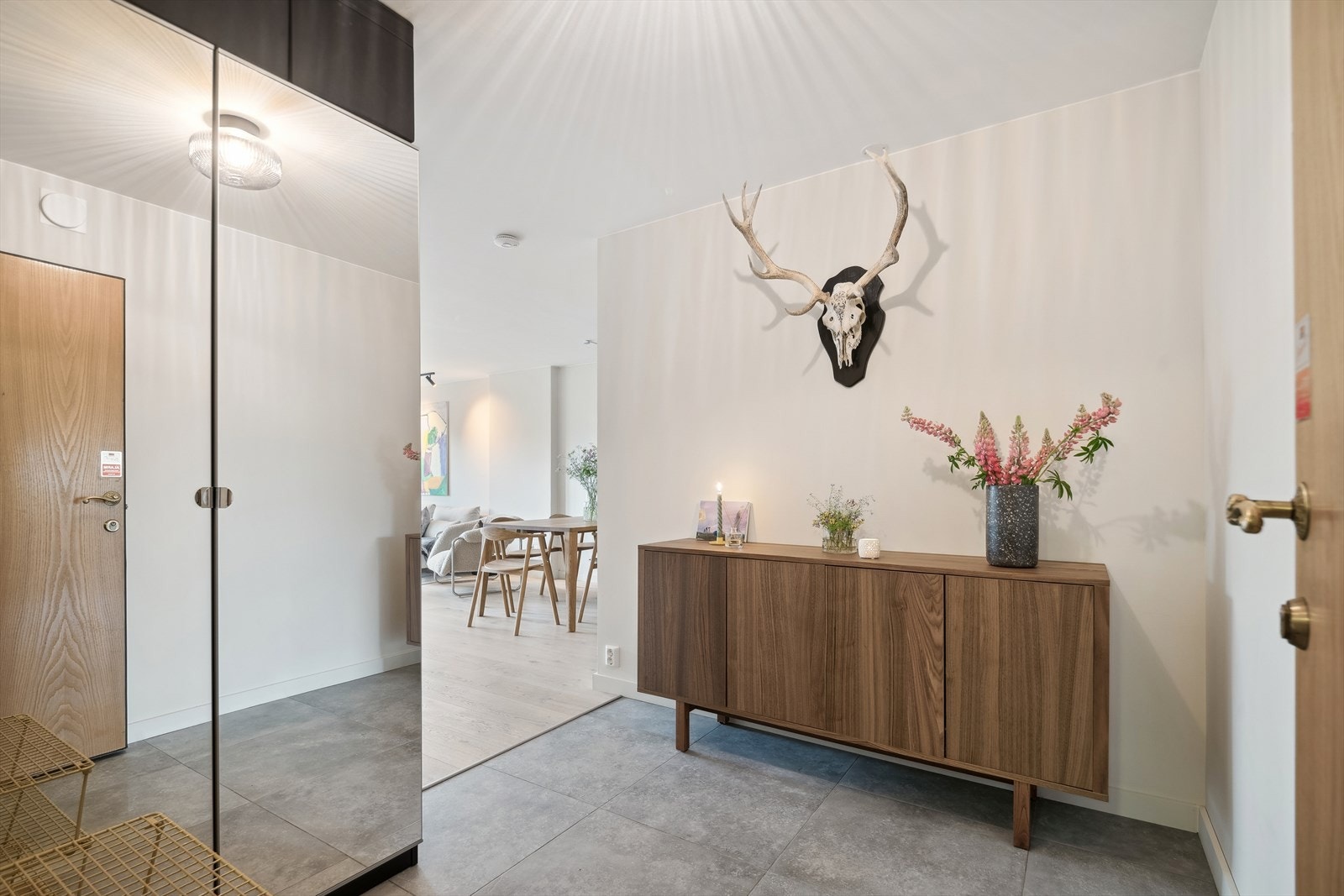 Romslig entré med fliser på gulvet med varmekabler. Praktisk garderobeskap med speilfronter som gir rom for mye oppbevaring. Galleribilde