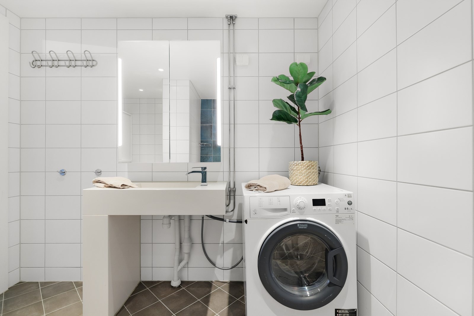 Servantinnredning med overskap og opplegg og plass til både vaskemaskin og tørketrommel. Galleribilde