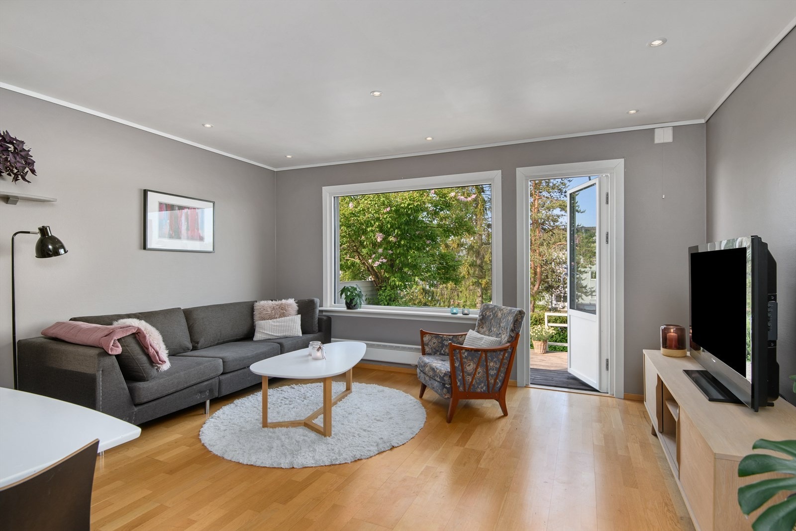 Stuene er malt i lyse farger og har himling med innfelte downlights Galleribilde