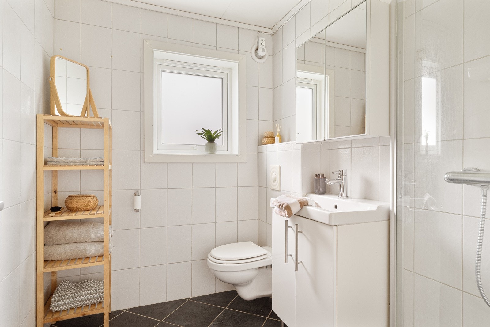 Dagene får en god start på badet, der sorte gulvfliser kombineres med hvite fliser på veggene. Galleribilde