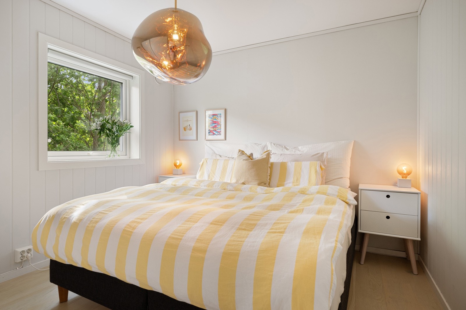 På soverommet er det plass til dobbeltseng med tilhørende nattbord, og klærne henges enkelt bort i en stor skyvedørsgarderobe med hvite fronter. Galleribilde