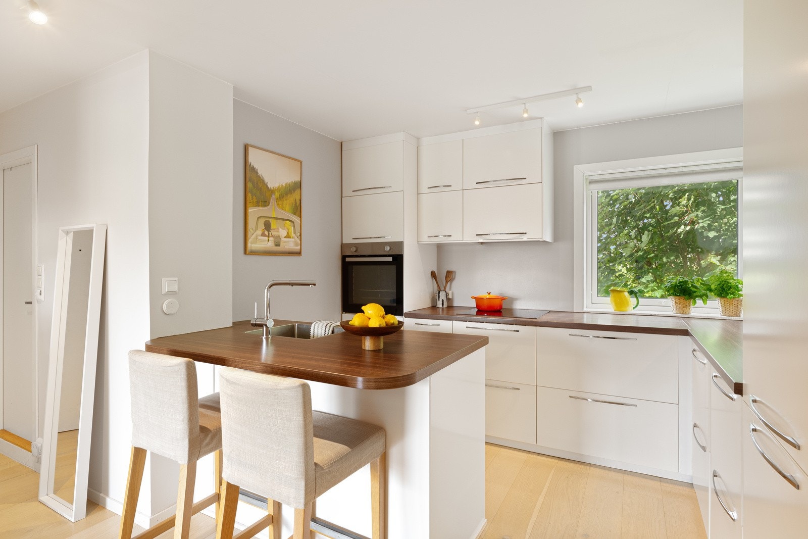 Ikea-innredningen fra 2014 har hvite, glatte fronter og benkeplate av laminat med nedfelt oppvaskkum. Galleribilde