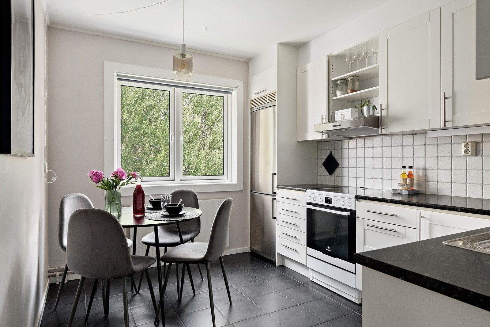 Separat kjøkken med en innredning bestående av profilerte fronter, laminert benkeplate, integrert oppvaskmaskin og frittstående komfyr med steketopp og kjøl/fryseskap. Galleribilde