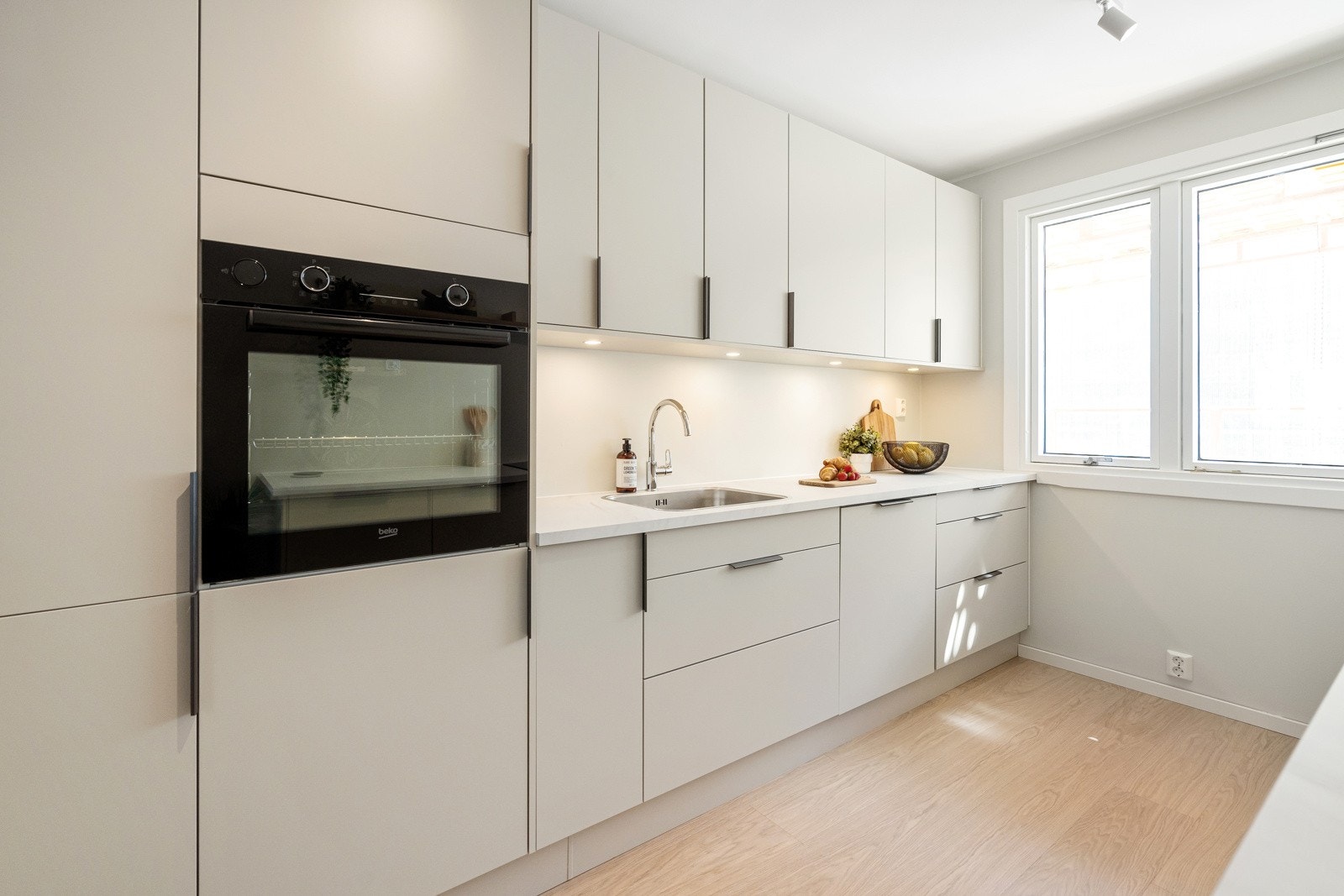 Eksklusivt HTH-kjøkken. Kjøkkeninnredningen består av lyse, glatte fronter og benkeplate i laminat. Galleribilde