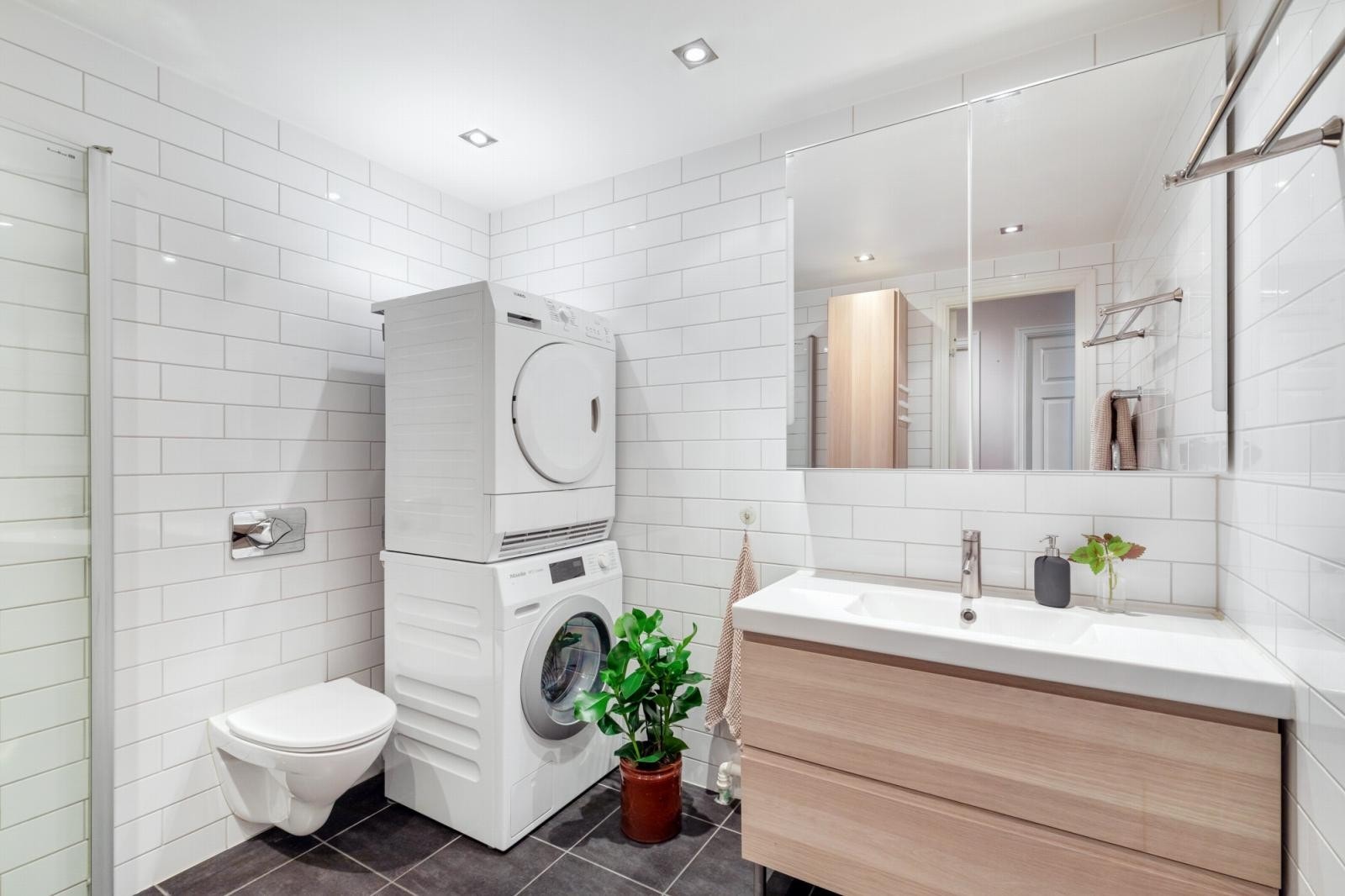 Godt vedlikeholdt bad med gulvvarme, opplegg til både vaskemaskin og tørketrommel samt praktisk skapløsning på vegg. Galleribilde