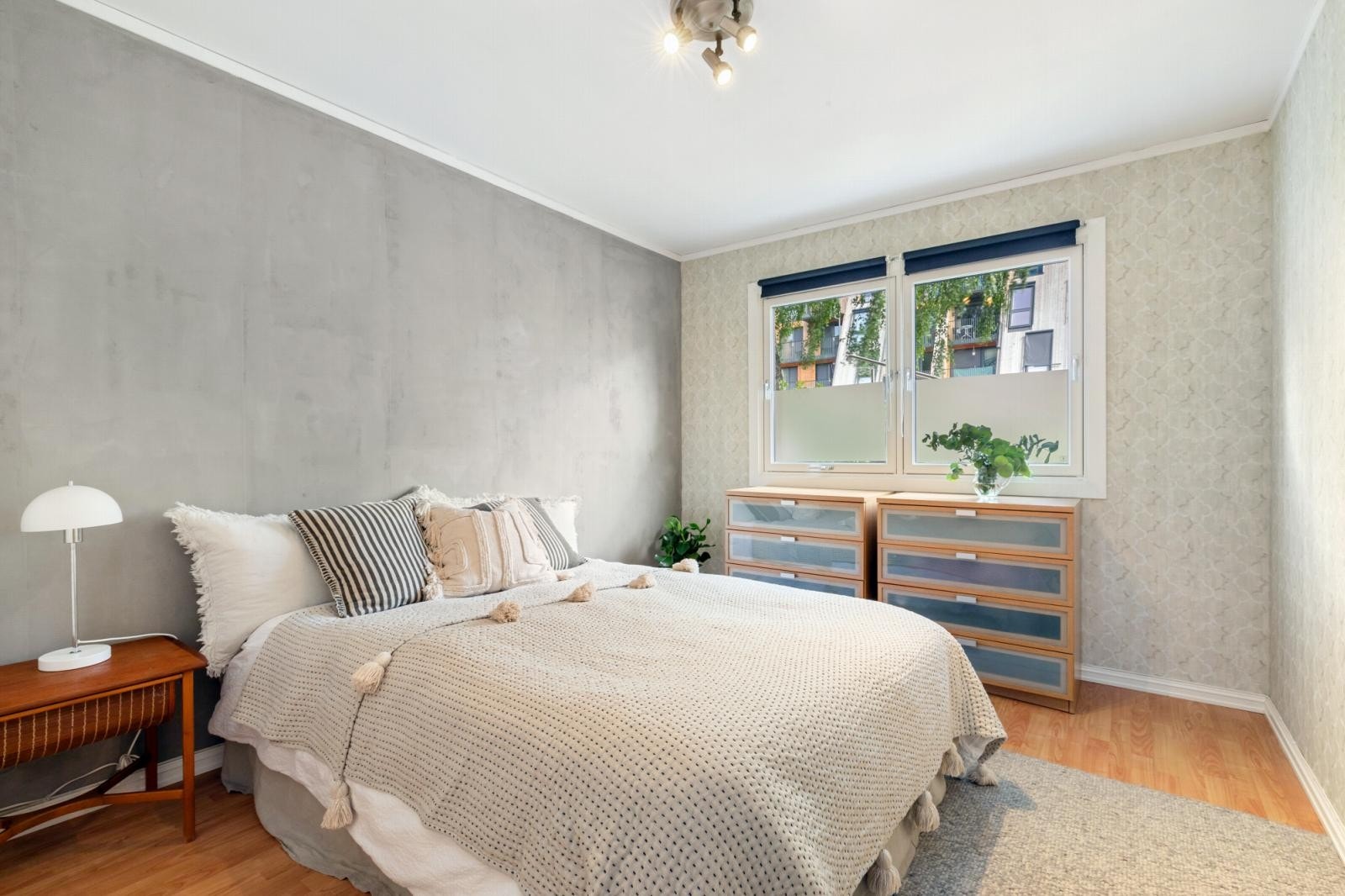 Luftig soverom med plass til dobbeltseng, nattbord og en oppbevaringsløsning. Galleribilde