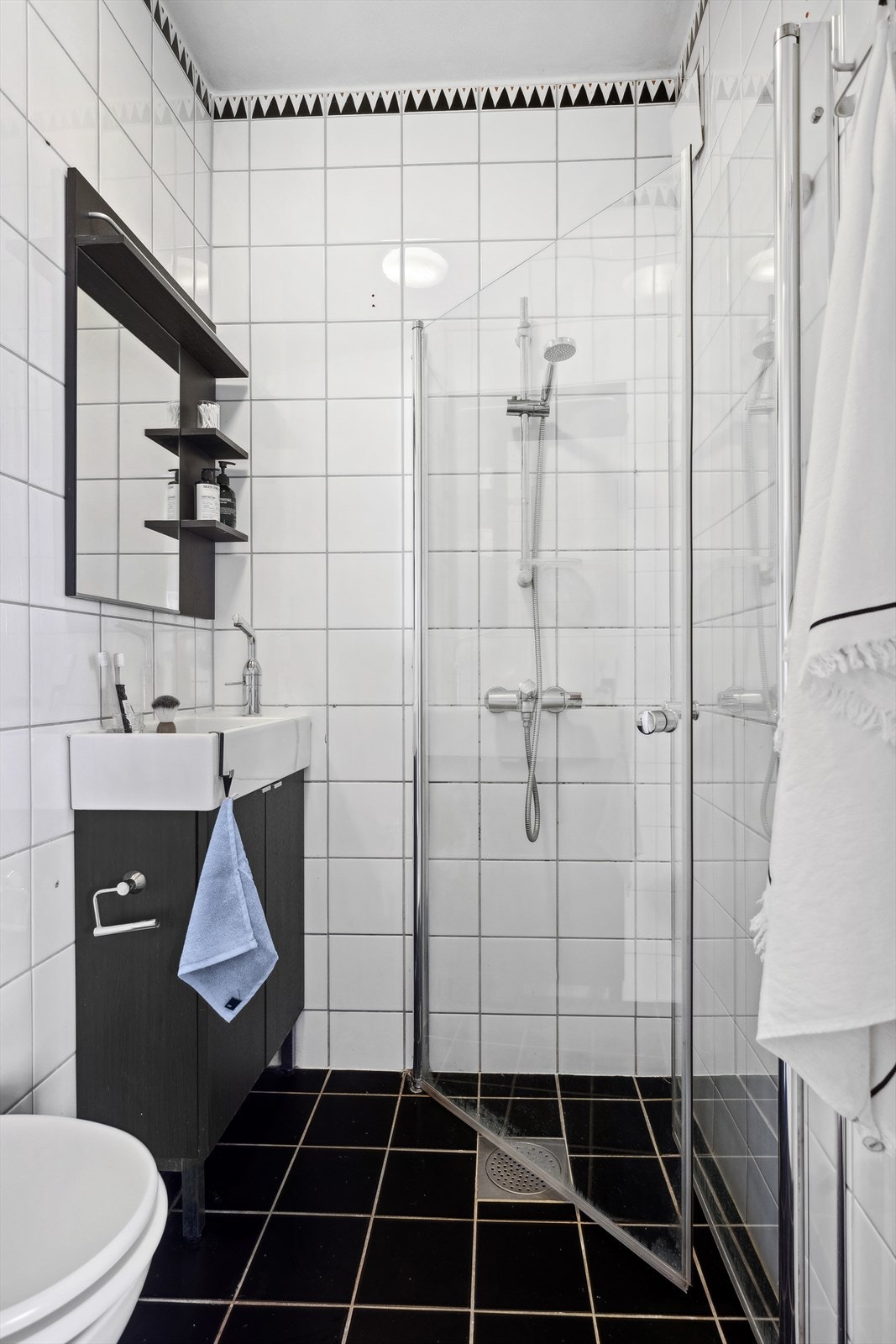 Pent flislagt bad fra 1999. Badet inneholder frittstående toalett, dusj med dusjhjørner, servant med ett-greps blandebatteri og servantskap Galleribilde