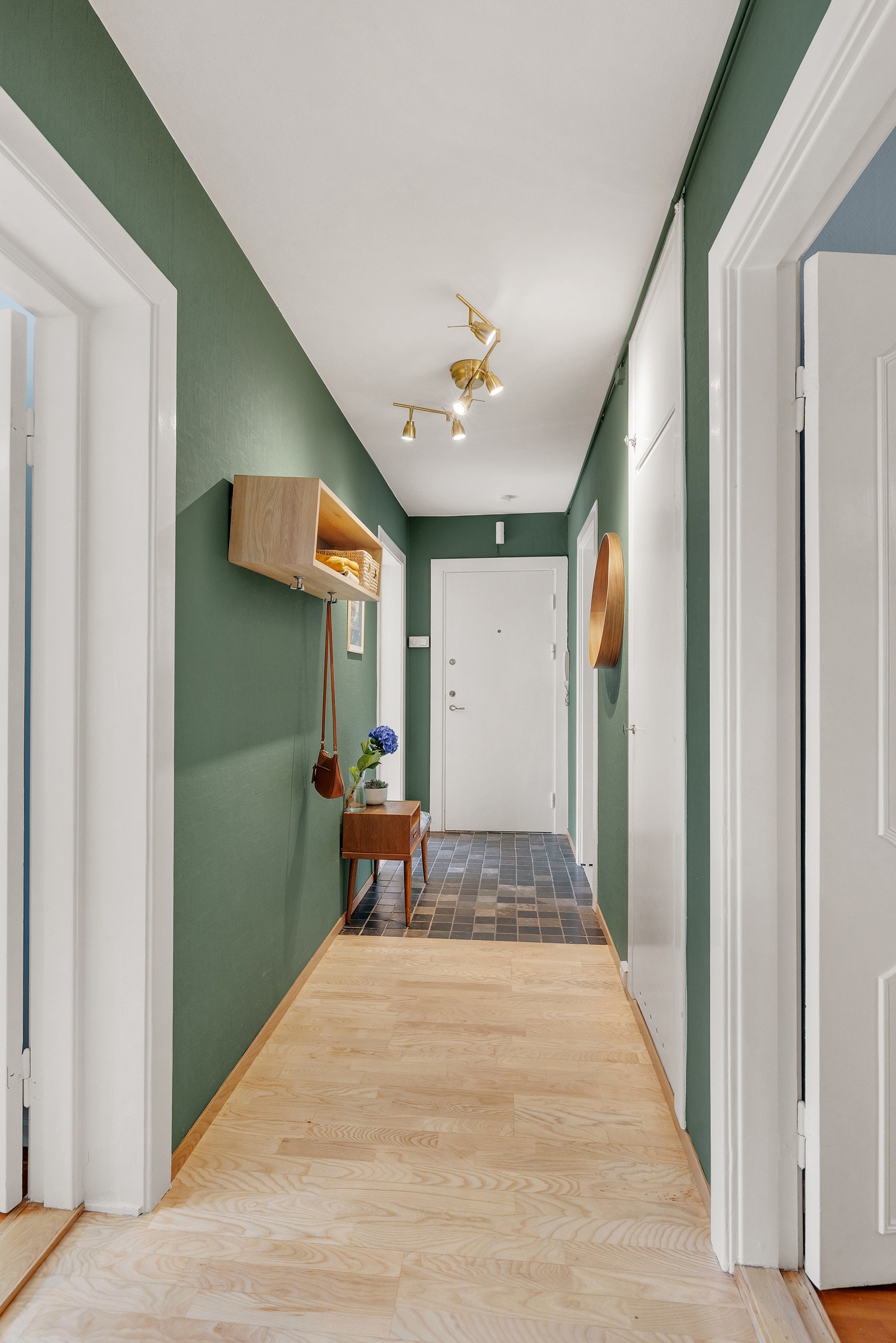 Entréen har fliser på gulv innenfor inngangsdøren og lys tre-stavs parkett og malte slette farger på vegger. Galleribilde