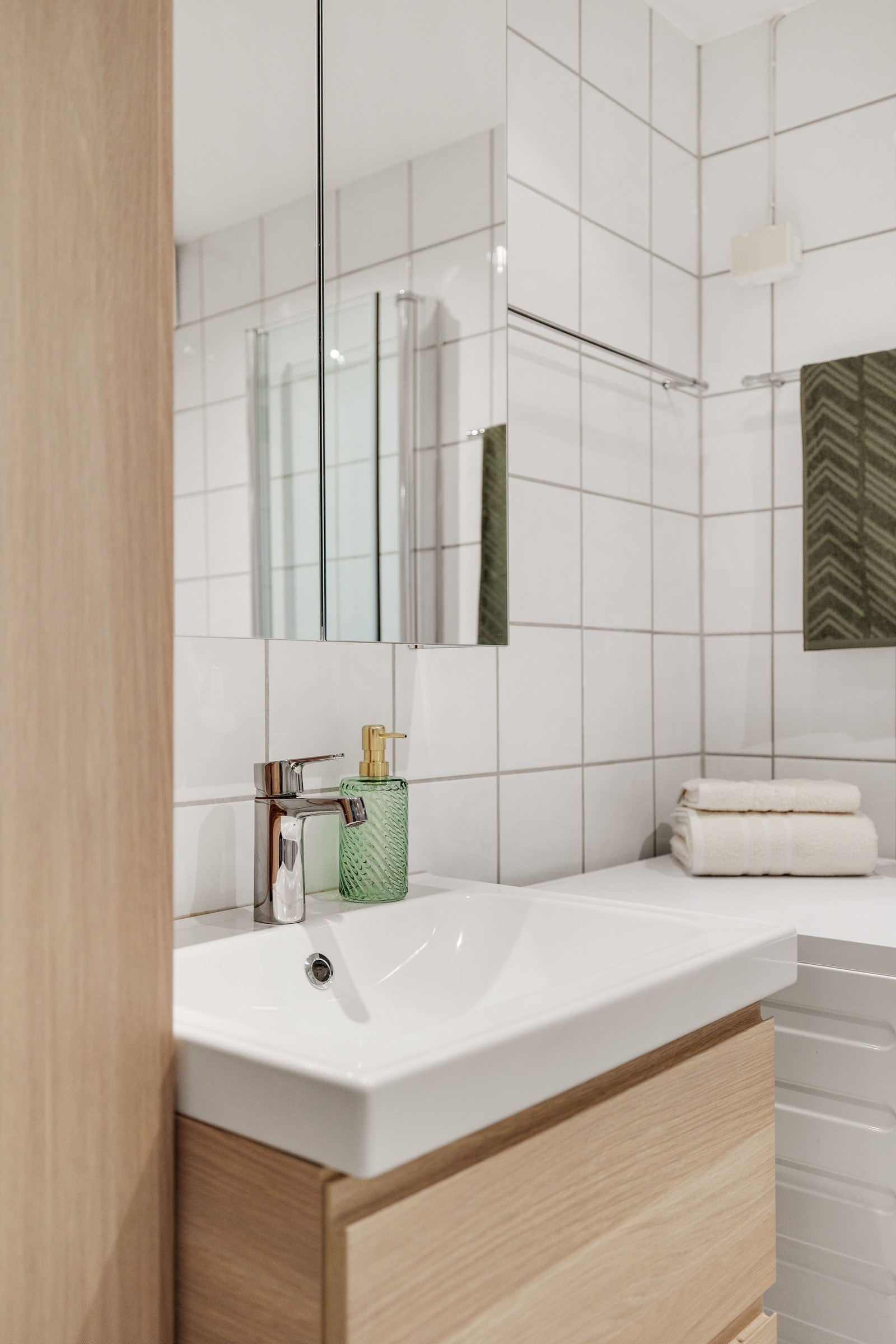 Badet er av god størrelse og inneholder innredning med skuffer og heldekkende servant, vegghengt høyskap og speilskap. Dusjhjørne med innfellbare dører og gulvmontert toalett. Galleribilde