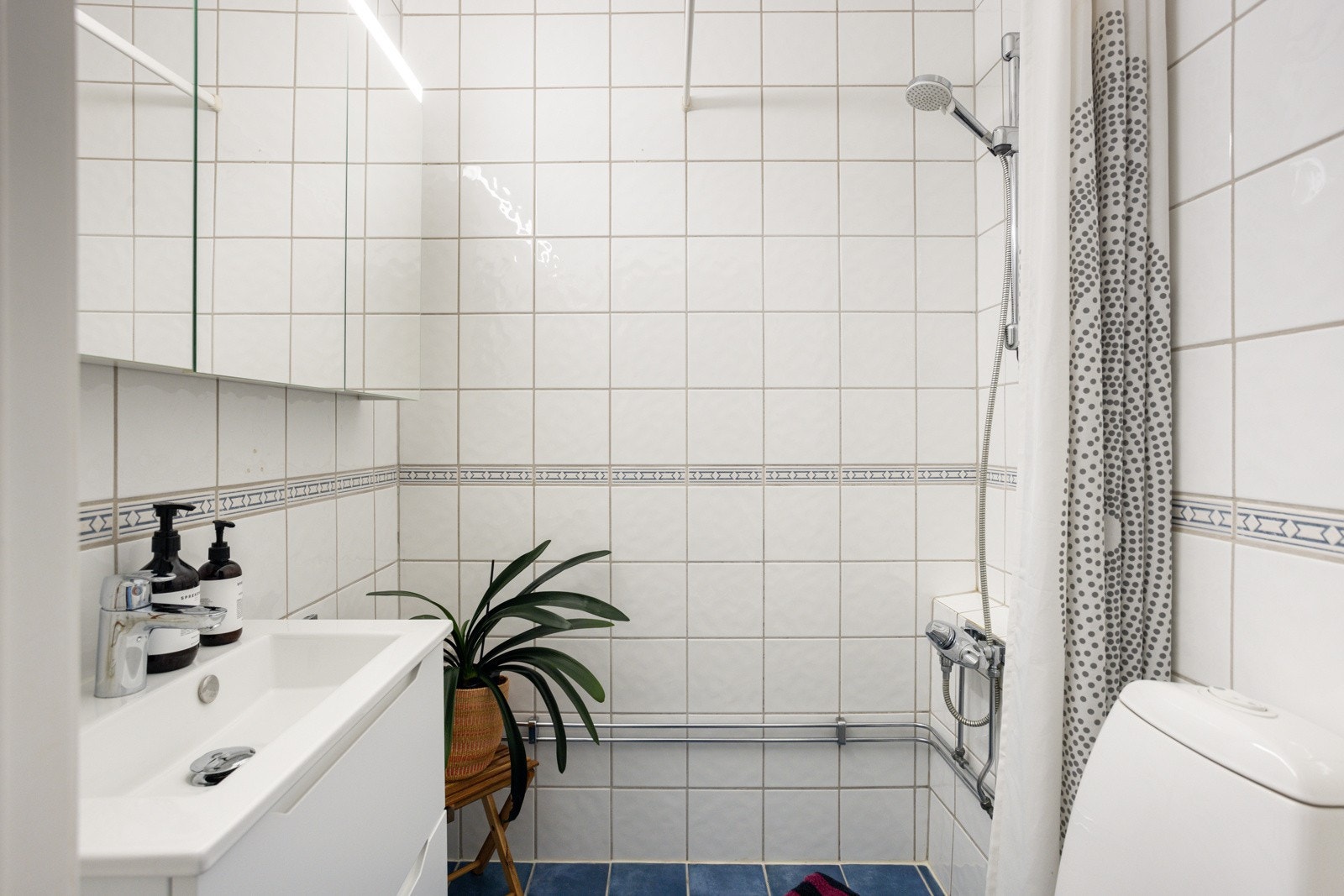 Moderne baderomsinnredning fra 2023 med skuffer og heldekkende servant, nytt armatur samt vegghengt speilskap over. Plass og opplegg til vaskemaskin i tillegg er det tilgang til fellesvaskeri i kjeller. Galleribilde