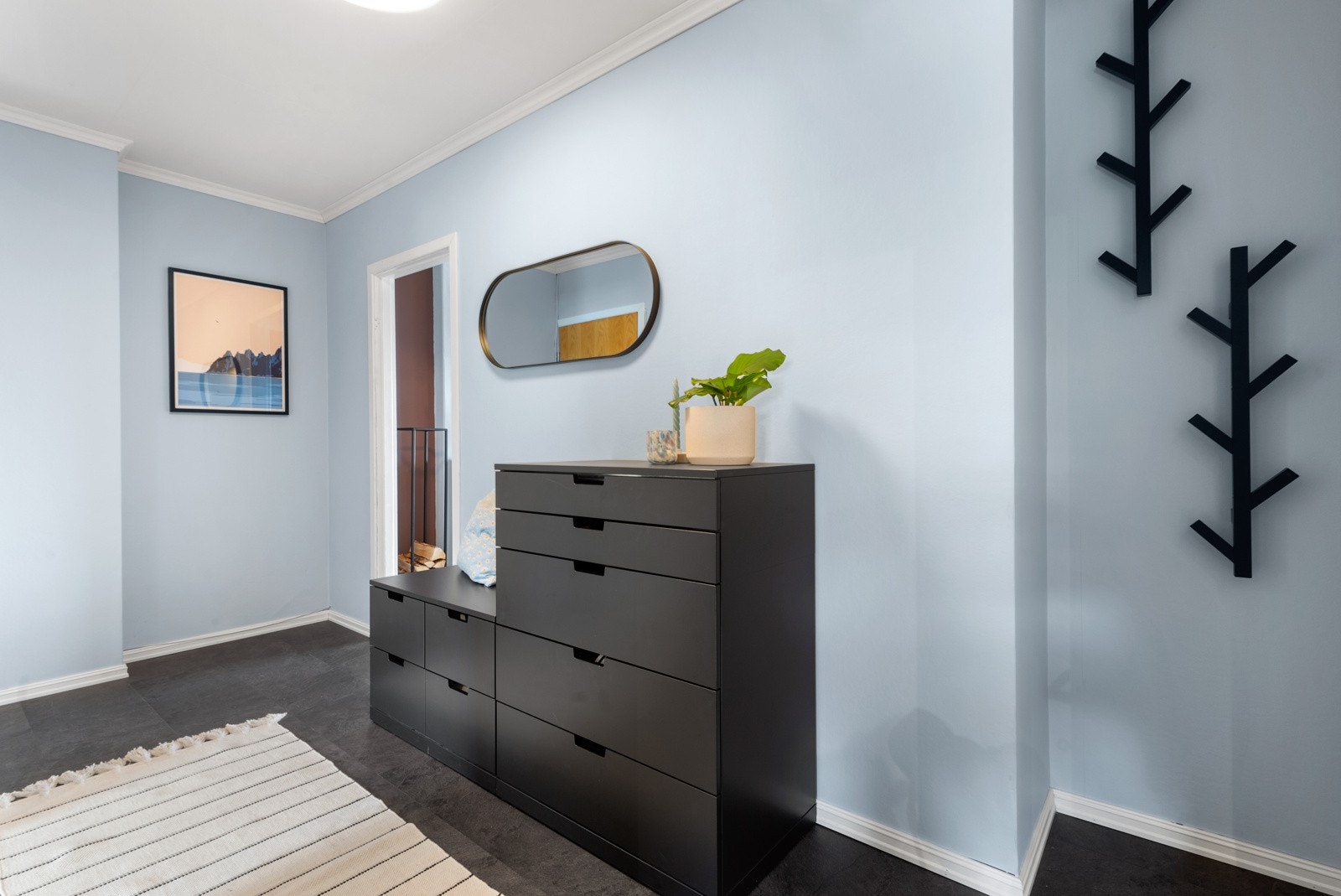 Entréen er malt i en innbydende farge som også er gjennomgående for resten av boligen. Rommet er av god størrelse med god plass til oppbevaringsmøblement. Galleribilde