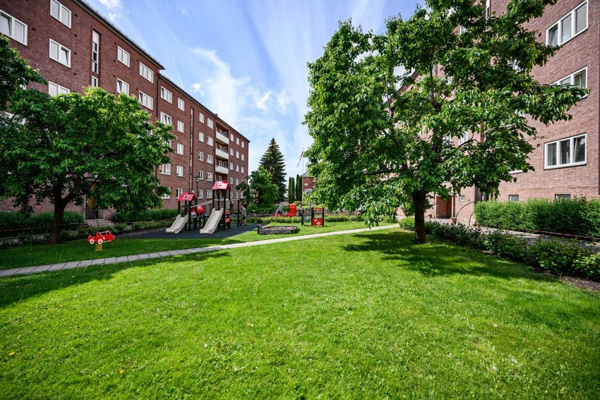 Tomten er pent opparbeidet med trær, busker og blomster. Galleribilde