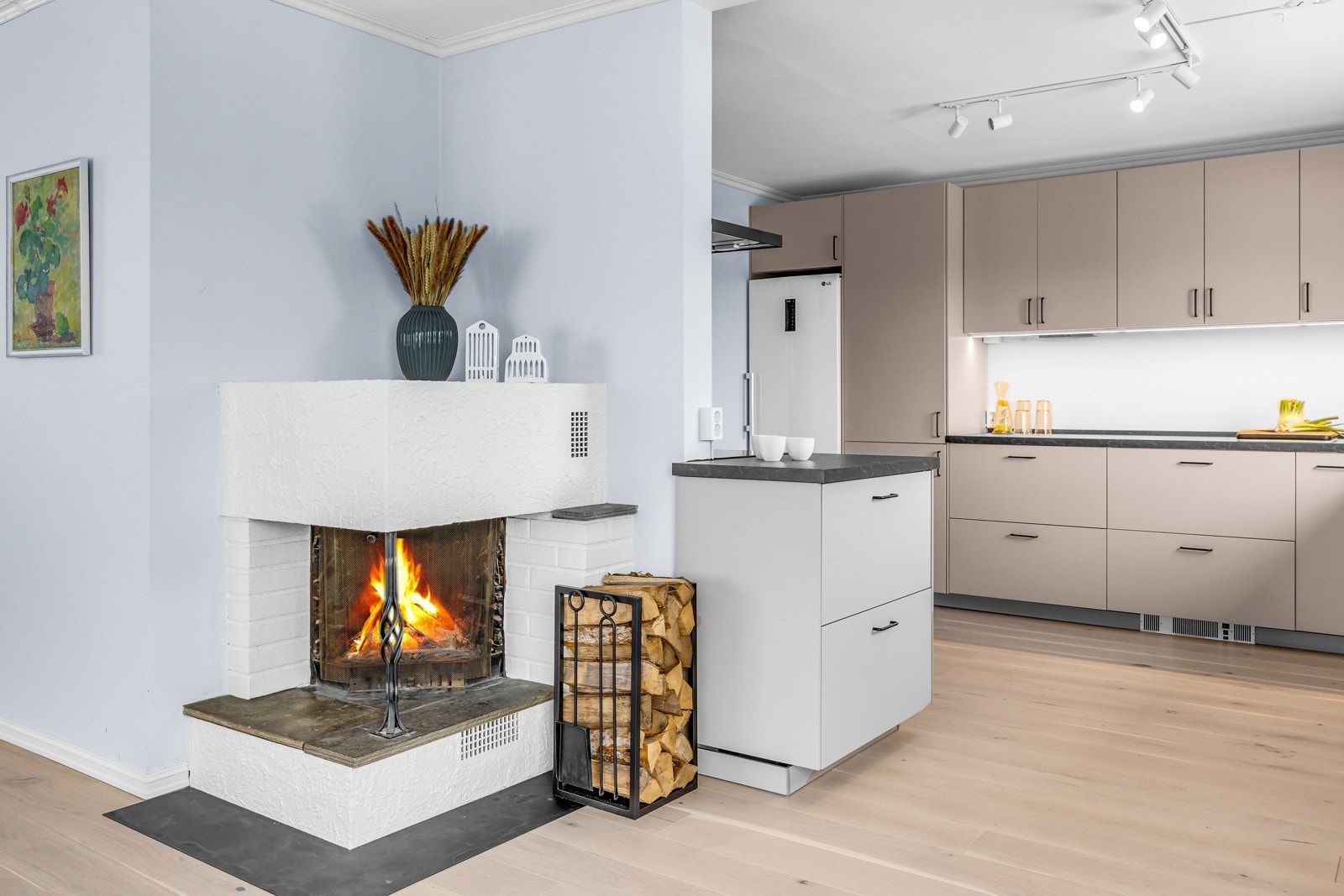 Koselig og funksjonell peis mellom kjøkken og stue Galleribilde