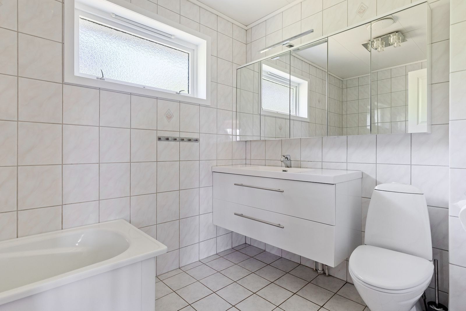 Lyst og pent bad i 1. etasje med badekar og godt med skapplass Galleribilde