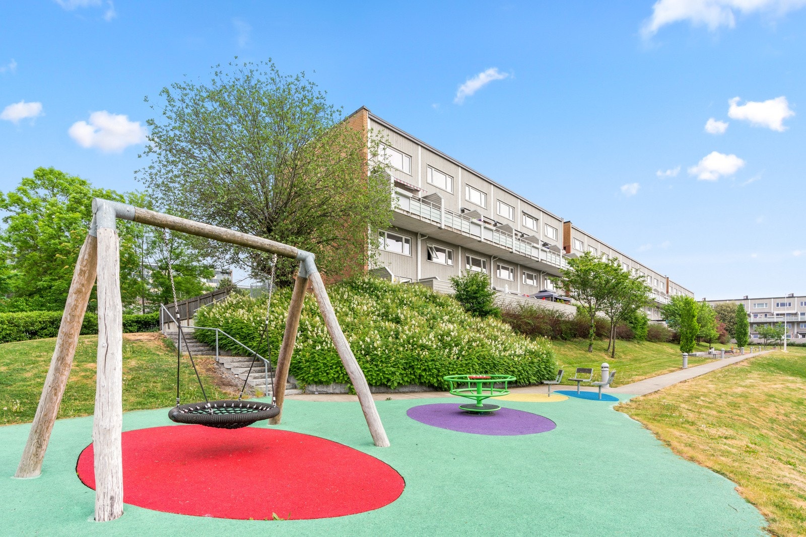 Pent opparbeidede fellesarealer med plener og beplantning, lekeplass og sittegrupper samt asfalterte internveier, gangstier og parkeringsarealer. Galleribilde