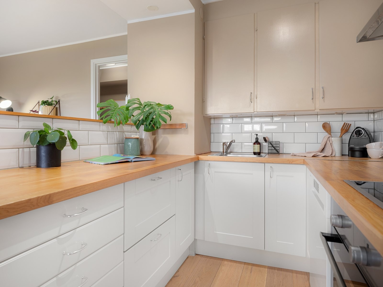 Her er det en sjarmerende kombinasjon av eldre, malte overskap og en moderne hvit skapinnredning fra IKEA montert i 2008 og 2013. Det er også god benkeplass for den som liker å kokkelere. Galleribilde