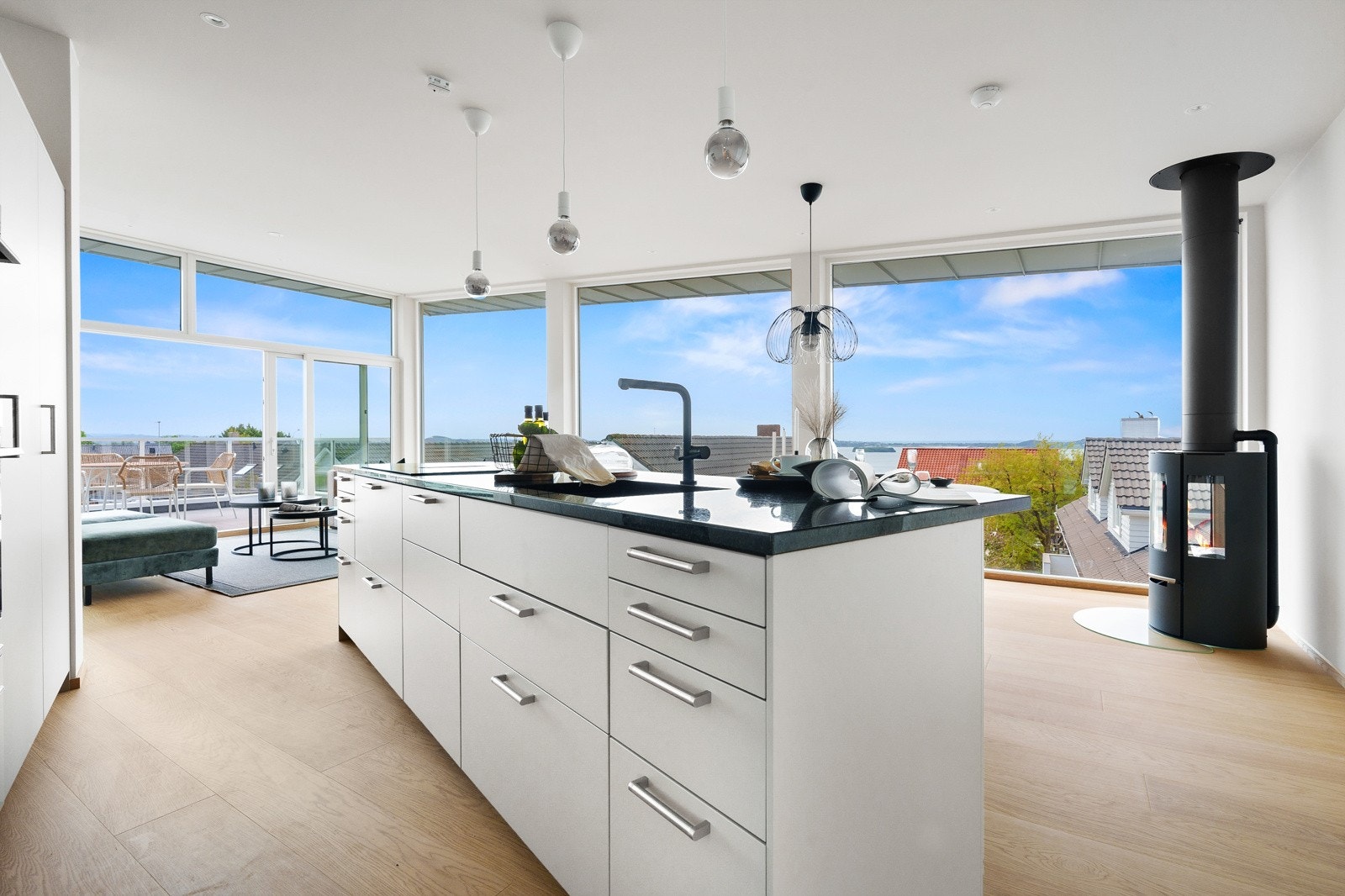 Praktisk kjøkken med stor øy som fungerer som arbeidsflate og samlingspunkt. Galleribilde