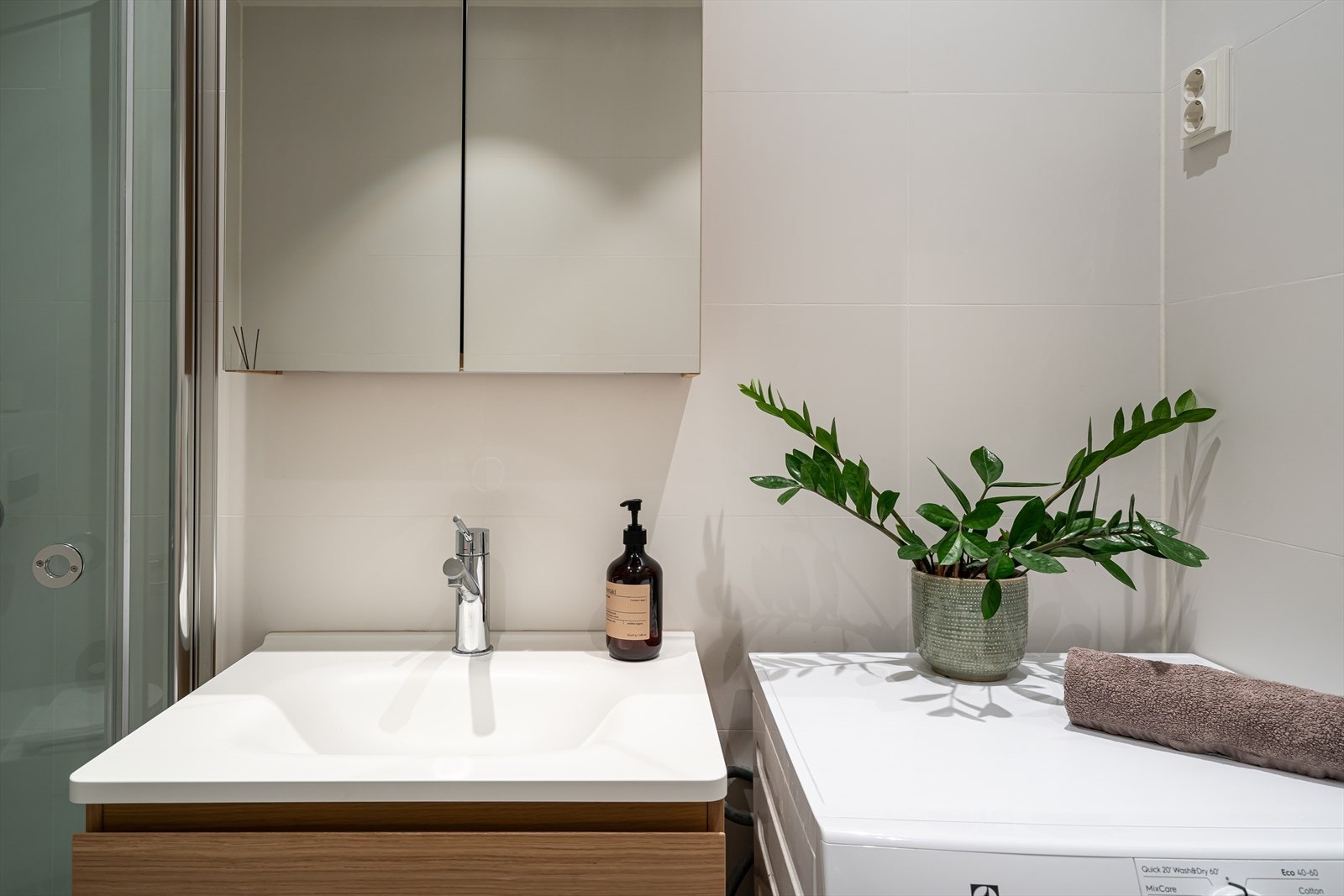 Badet er innredet med underskap, servant, speil med belysning og dusjsone med innfellbare dusjvegger. Galleribilde