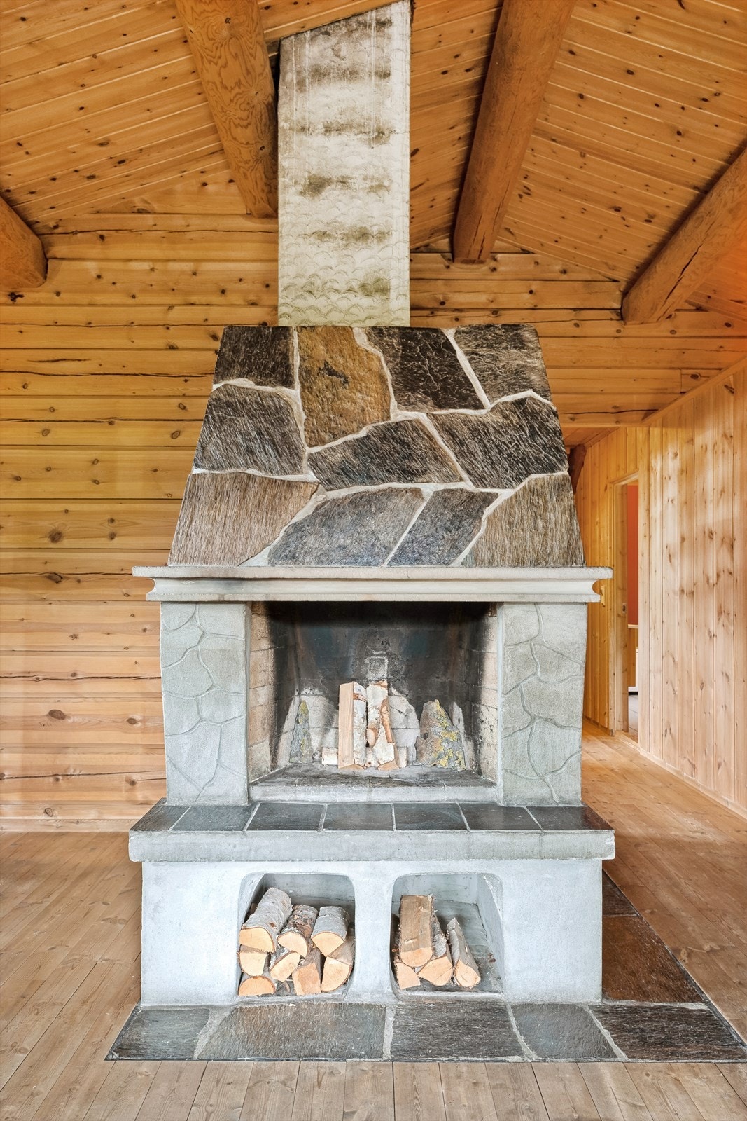 Midt i stua er det en åpen peis som bidrar til god varme og stemning. Galleribilde