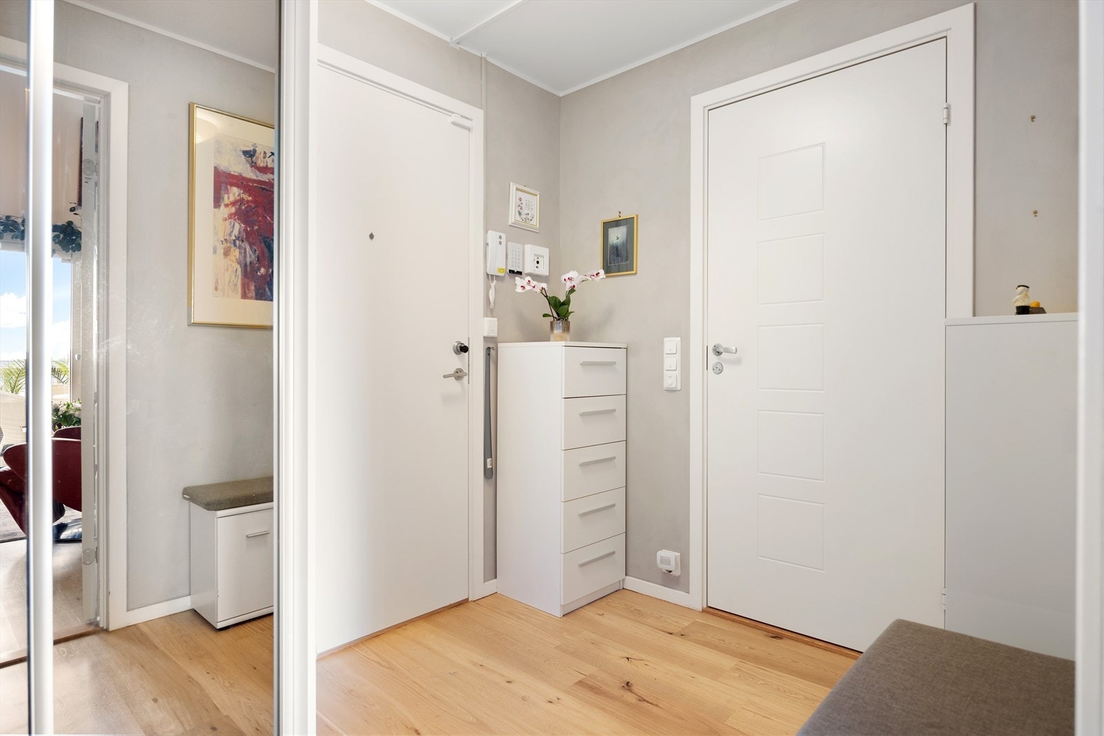Velkommen inn! Leiligheten har en innbydende entré som skaper et umiddelbart godt førsteinntrykk. Her kan du enkelt henge i fra deg yttertøy og sko i en praktisk skyvedørsgarderobe m/ speildører. Galleribilde