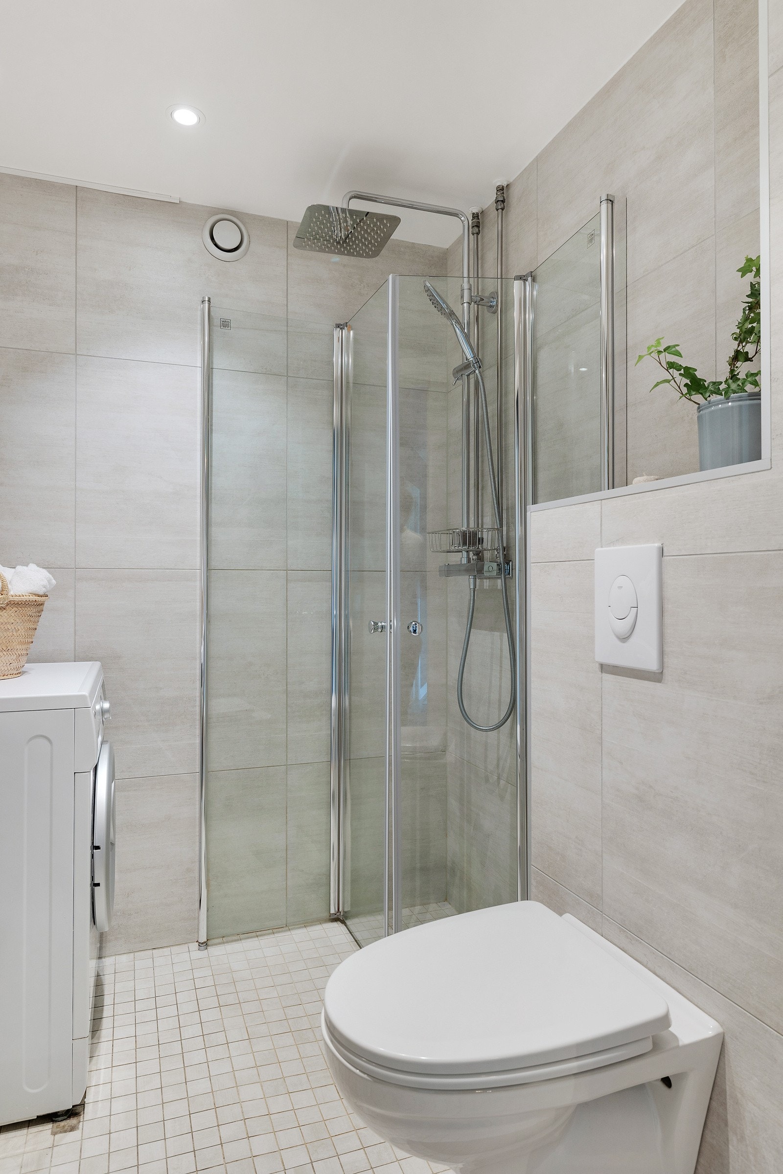 Badet består av vegghengt innredning med skuffer fra 2018 og ovenpåliggende servant, innmurt speil, vegghengt wc og dusjnisje med innfellbare dører og regnfallsdusj. Galleribilde
