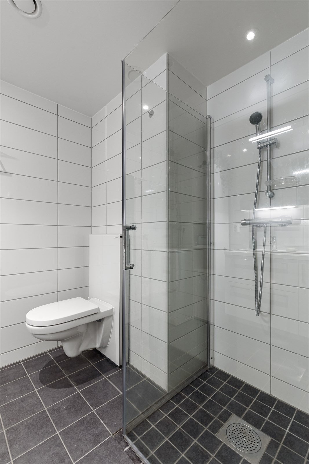 Badet har elektriske varmekabler i gulv og downlights i tak Galleribilde