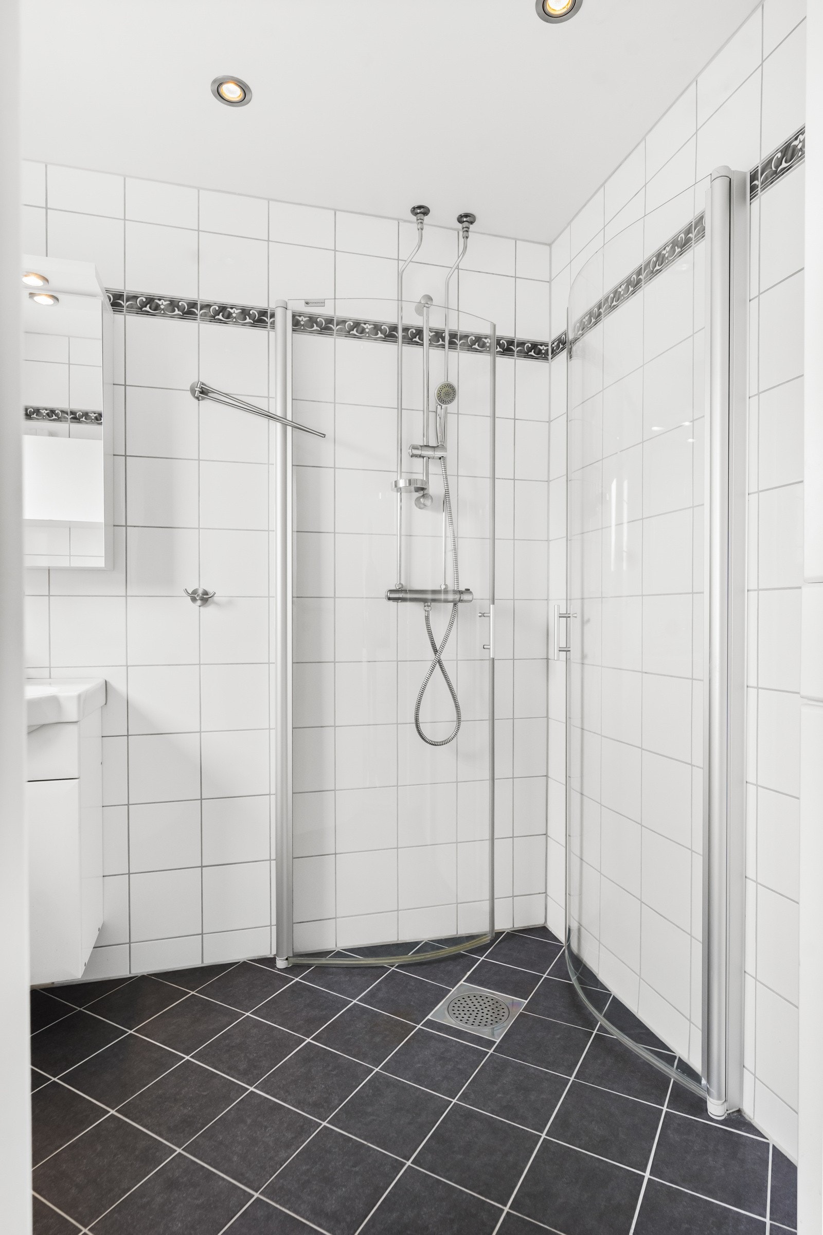 Dusjsone med dusjing direkte på gulv og vegg. Galleribilde