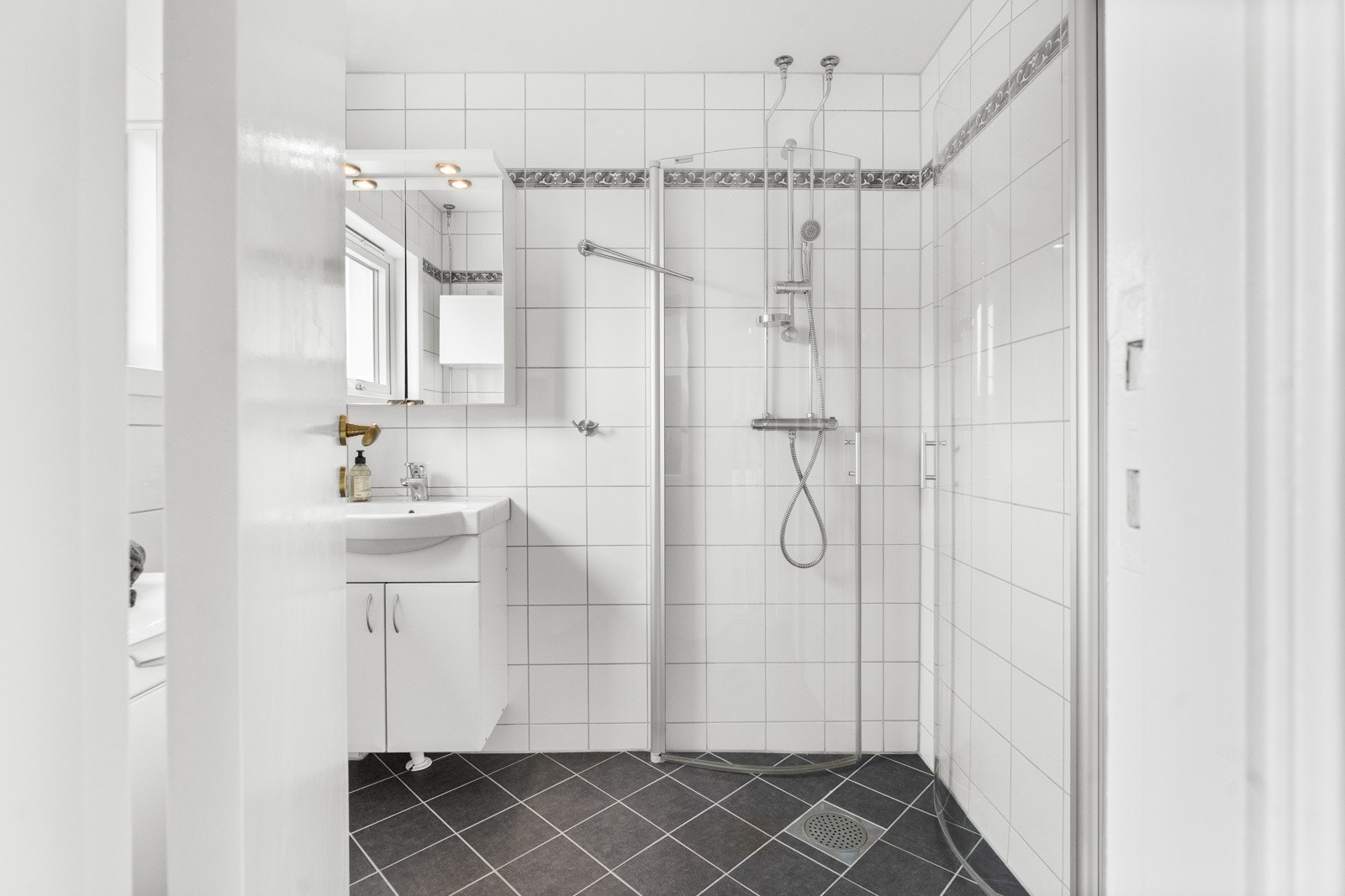 Bad med fliser på gulv og vegger utført i regi av borettslaget. Galleribilde