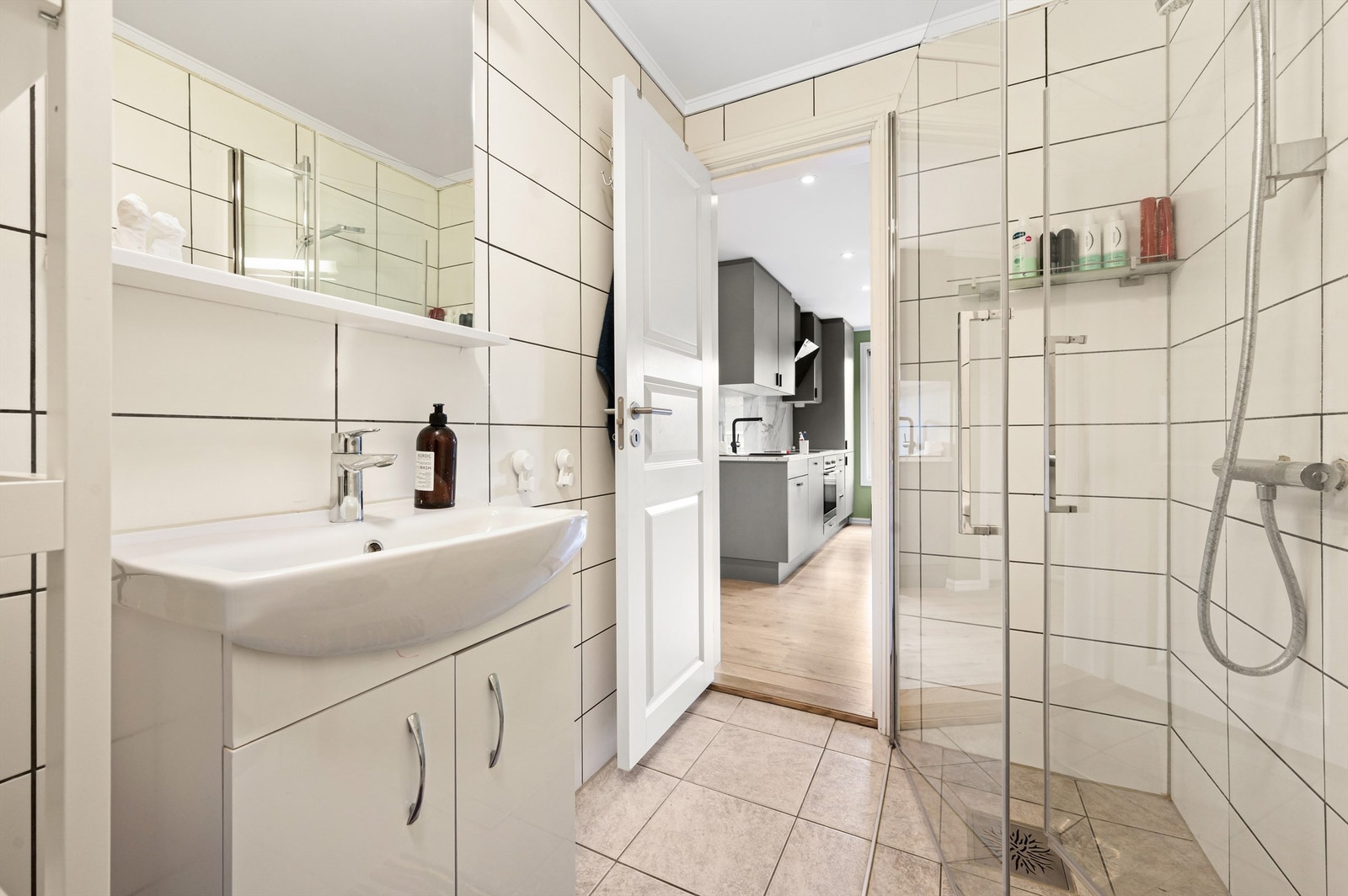 Videre har badet dusjhjørne med innfellbare dører i glass. Det er også opplegg for vaskemaskin. Galleribilde