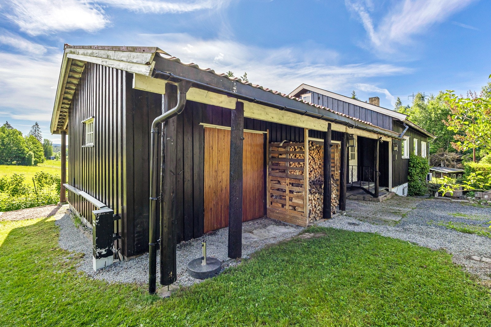 Delvis skrånende tomt opparbeidet med singlet og stensatt oppkjørsel, plenarealer og diverse beplantning Galleribilde