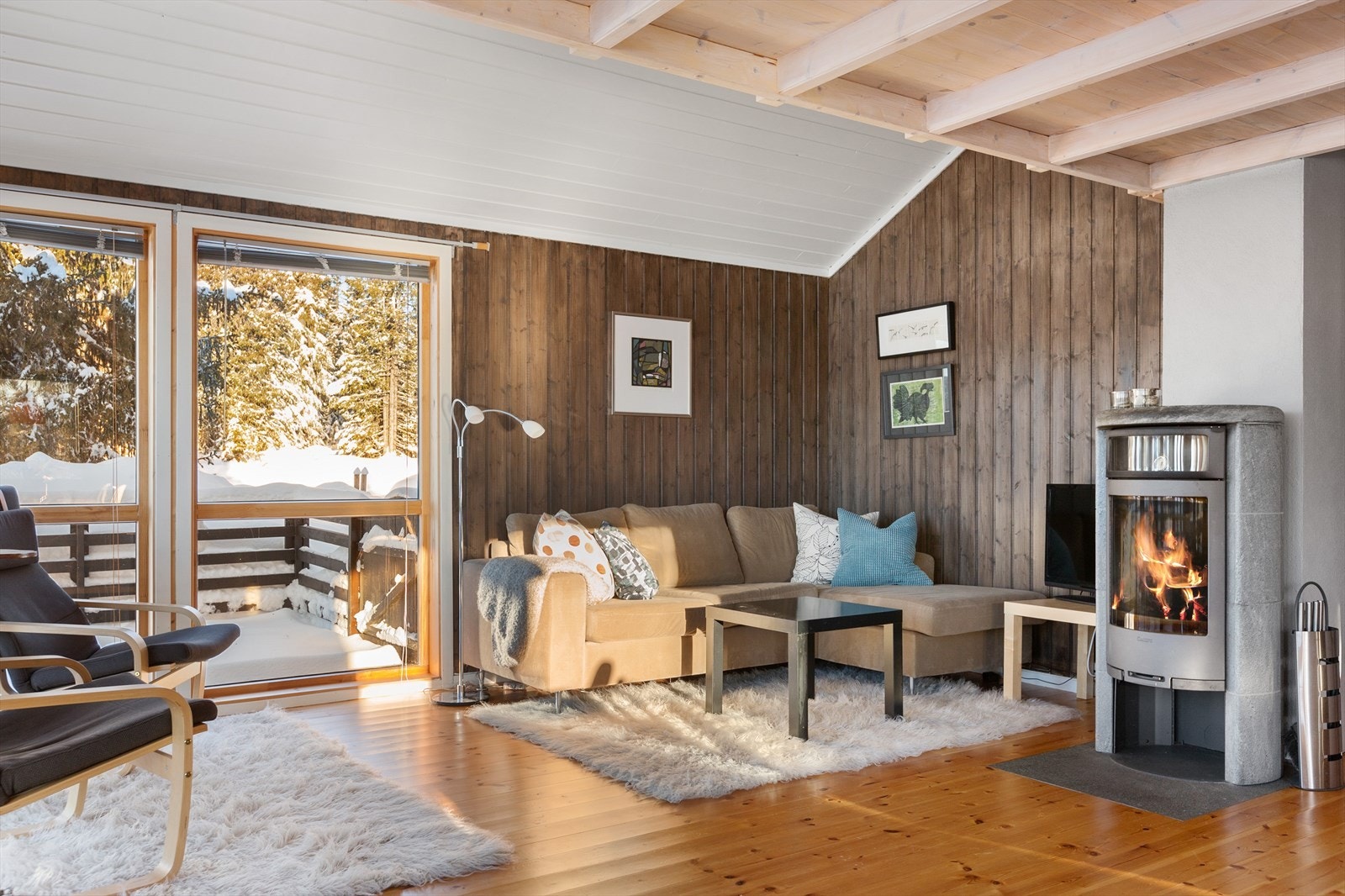 I himlingen er det lyst skråtak og veggene er beiset i tidsriktig farge. En stilig peisovn med kleberstein gir en hyggelig stemning til rommet. Galleribilde