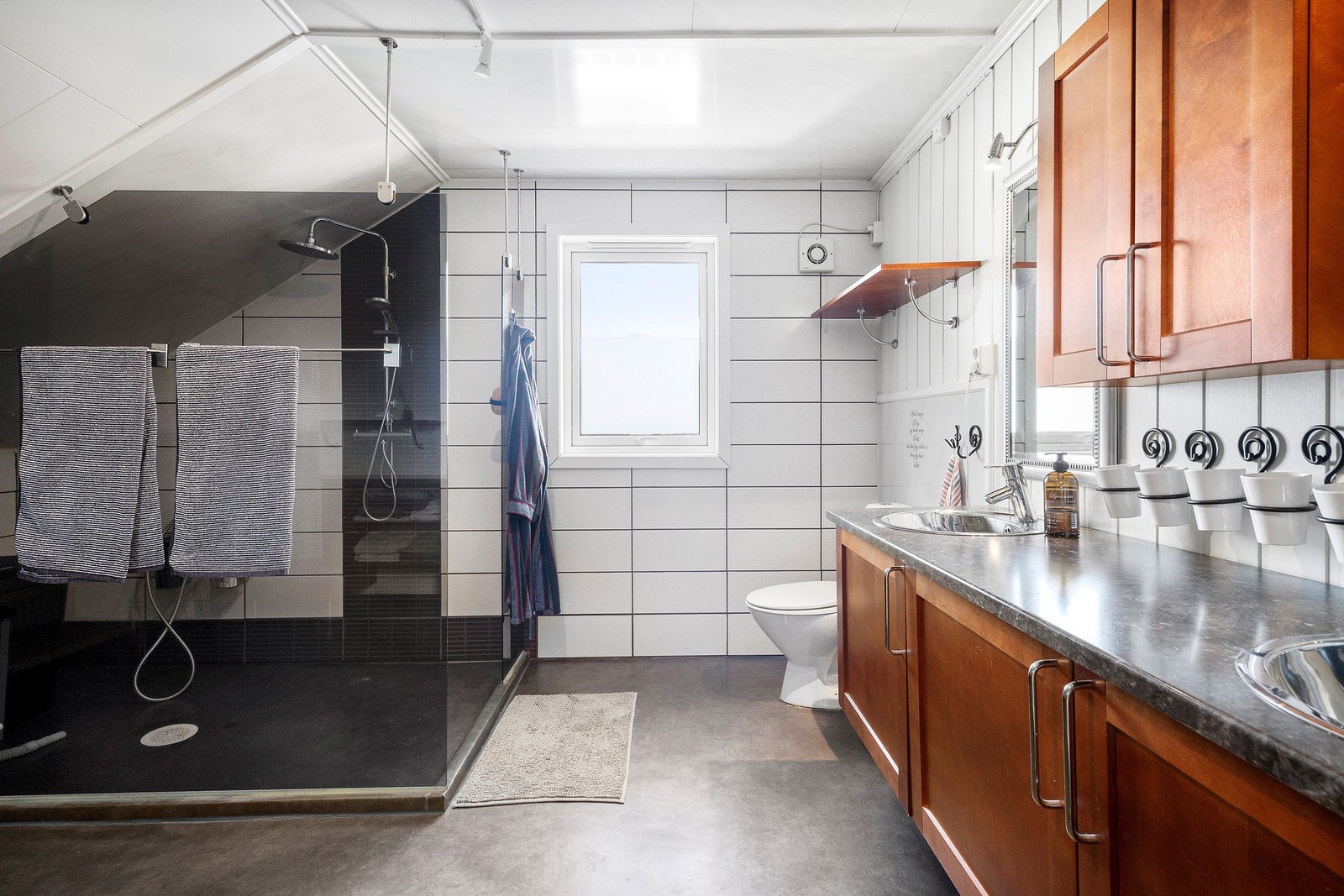 Badet er innredet med toalett, dusjsone og dobbel servant. Galleribilde
