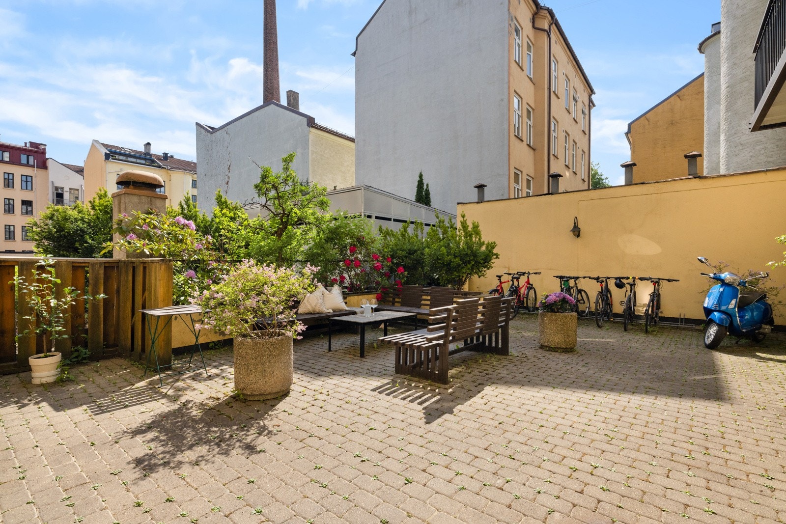 Sameiet disponerer hyggelige fellesarealer bestående av brosteinsbelagt underlag, sittegrupper, belysning, sykkelparkering samt diverse busker og beplantinger Galleribilde