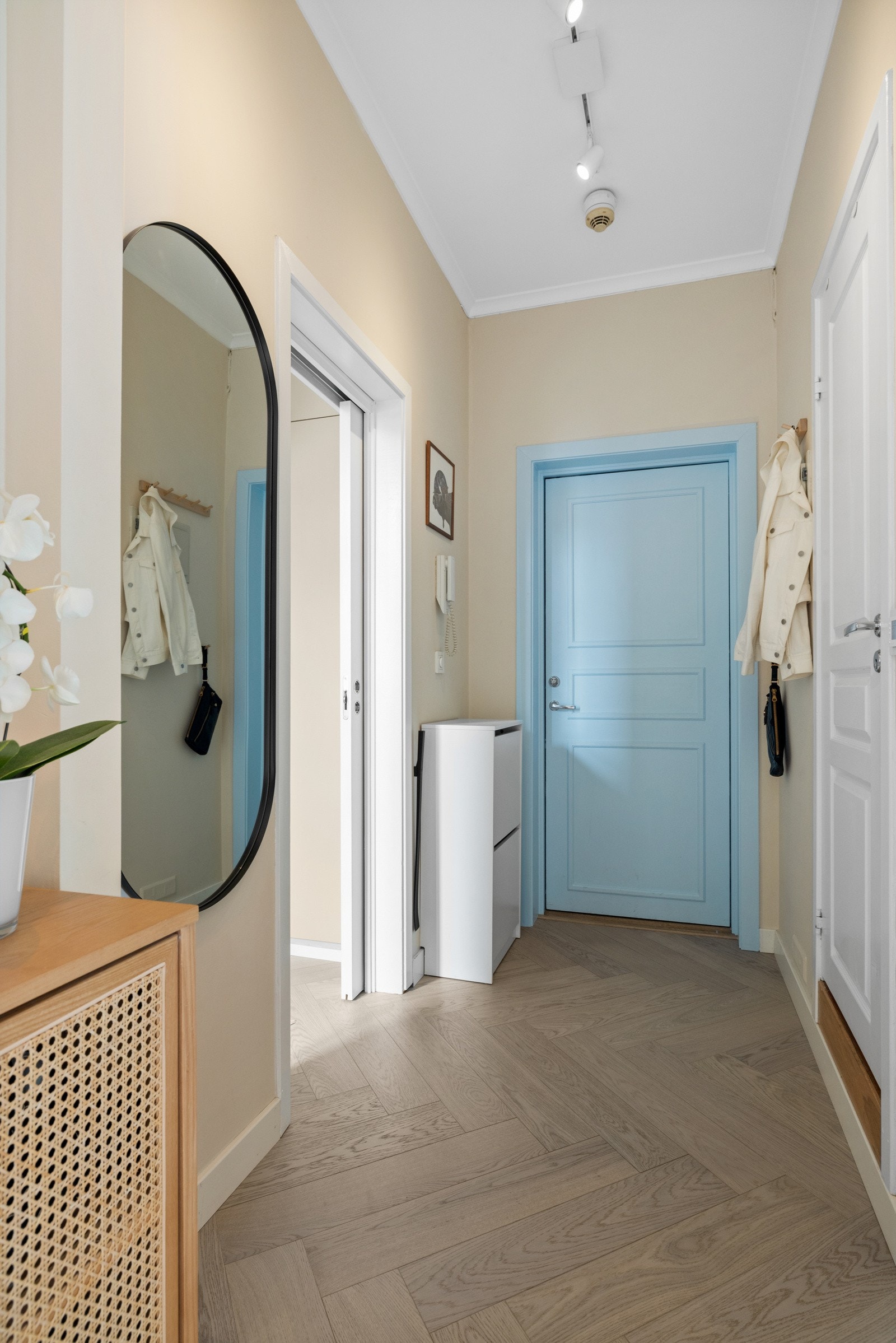 Inngangspartiet gir et godt førsteinntrykk av hva leiligheten byr på videre med bl.a. gulv bestående av fiskebeinsparkett, generøs himlingshøyde, slette malte flater og callinganlegg med portåpner Galleribilde