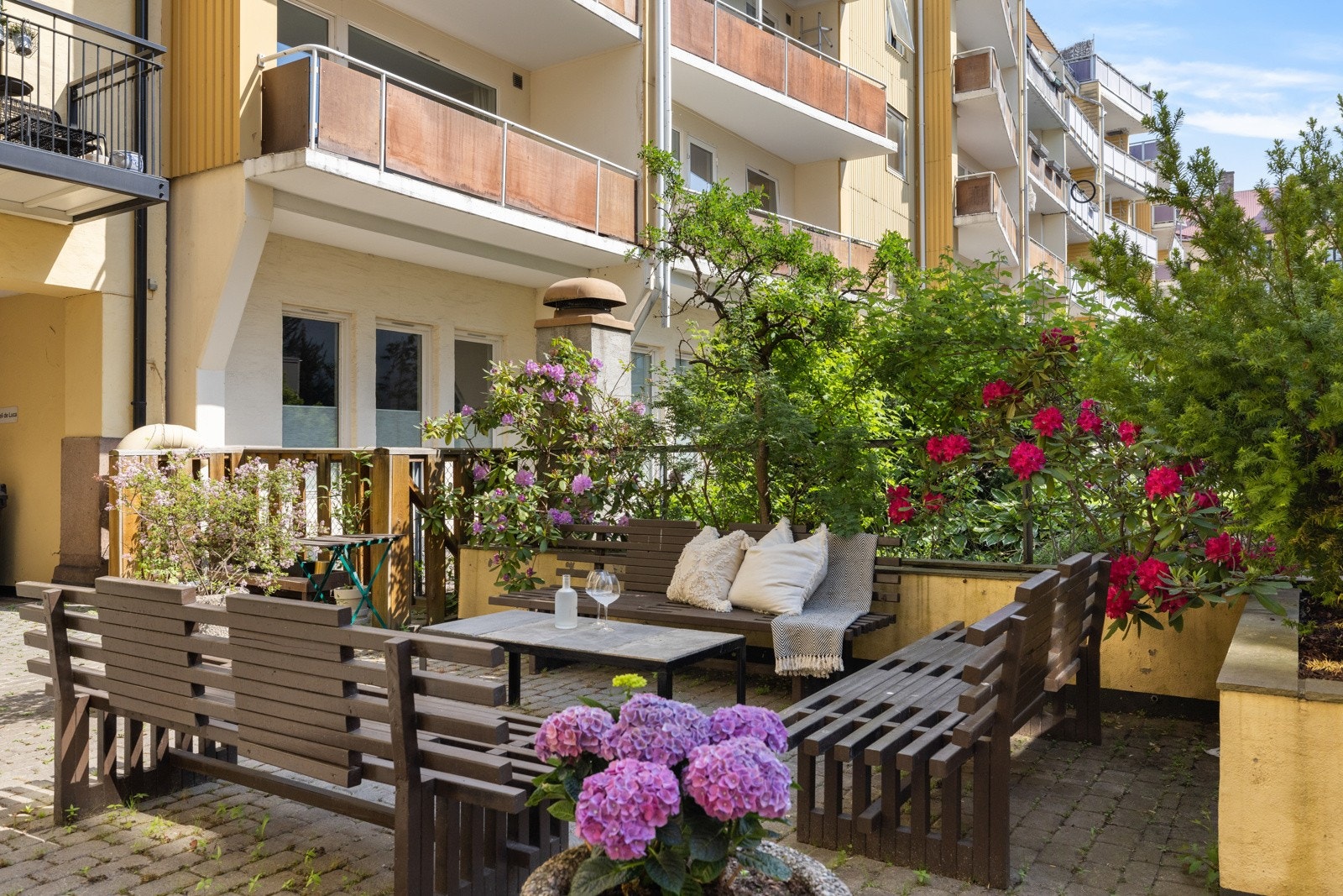 Bakgården fremstår som frodig på sommerhalvåret og er et fint sted å oppholde seg for store og små Galleribilde