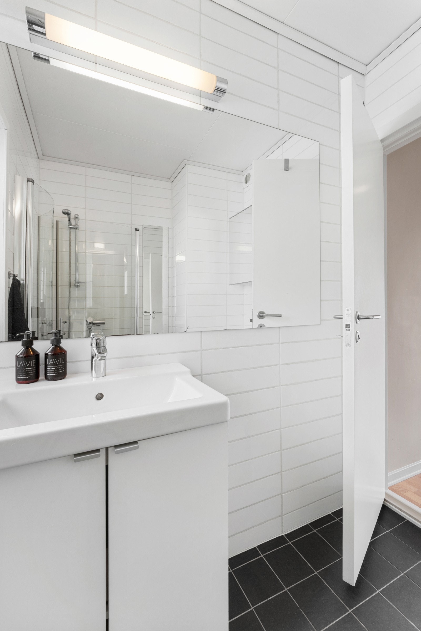 Badet er innredet med dusjhjørne, toalett og servant, i tillegg til skap. Galleribilde