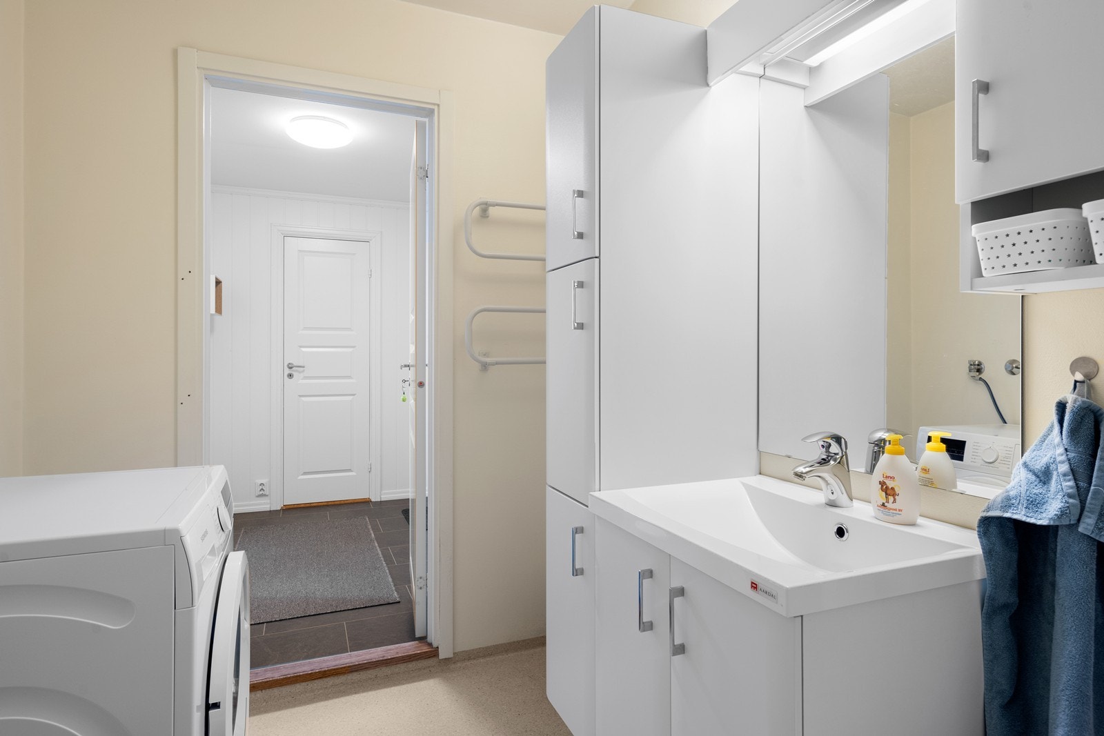 Badet har innredning med nedfelt servant, gulvfestet toalett, dusjkabinett og opplegg for vaskemaskin Galleribilde