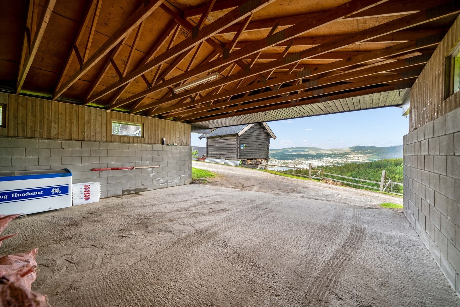 Dobbel garasje i tunet uten porter. Oppført ca. 2002. Grunnflate på ca. 55 m2. Garasjen er oppført på betongplate. Galleribilde