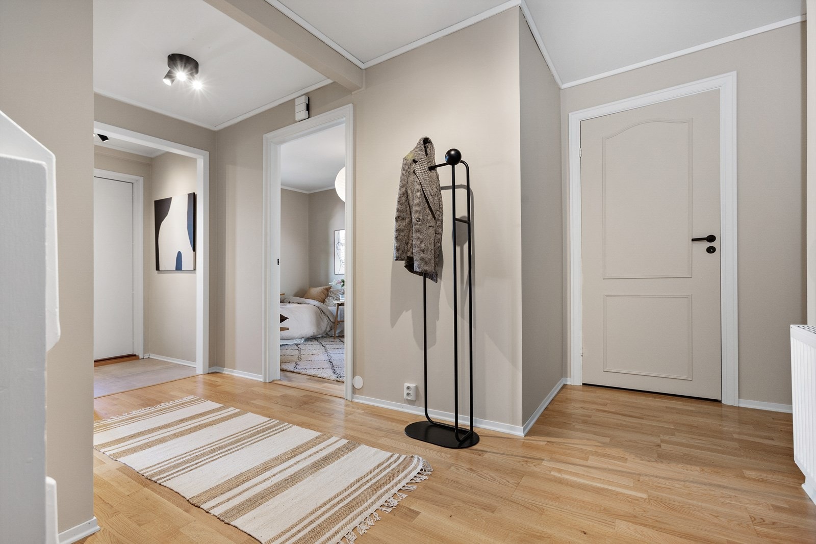 Ryddig og innbydende entre med plass til å henge fra seg yttertøy og sko Galleribilde