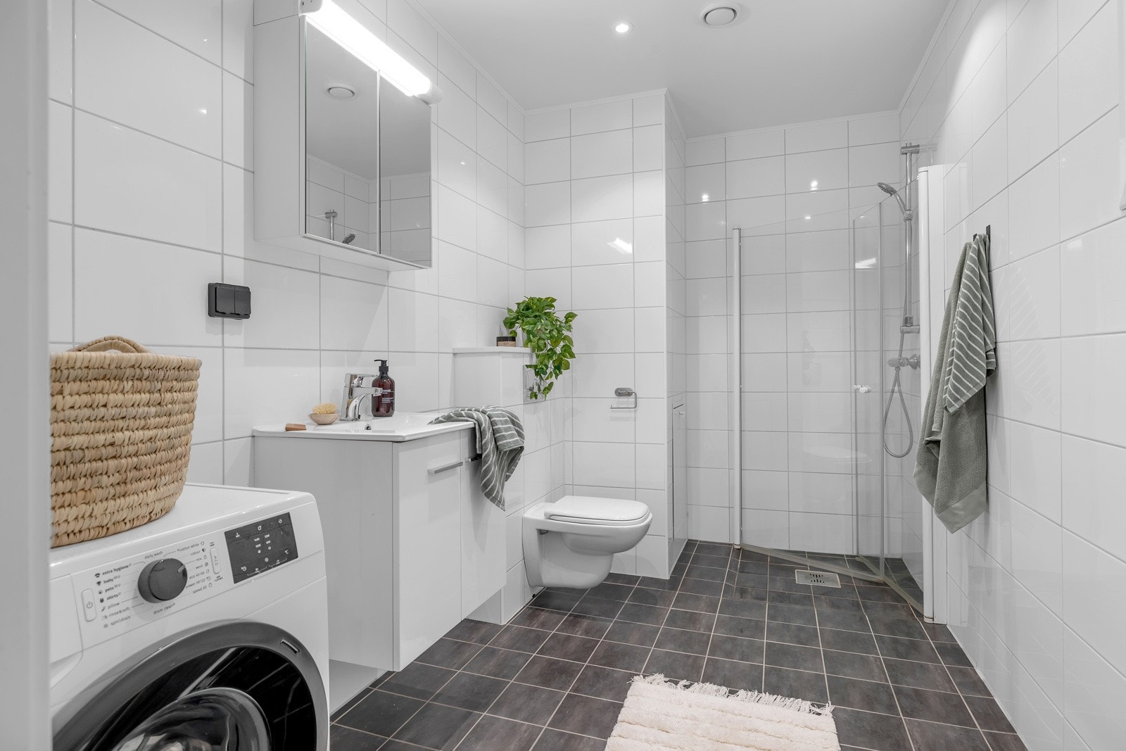 Badet er pent og praktisk med fliser på gulv og vegger Galleribilde