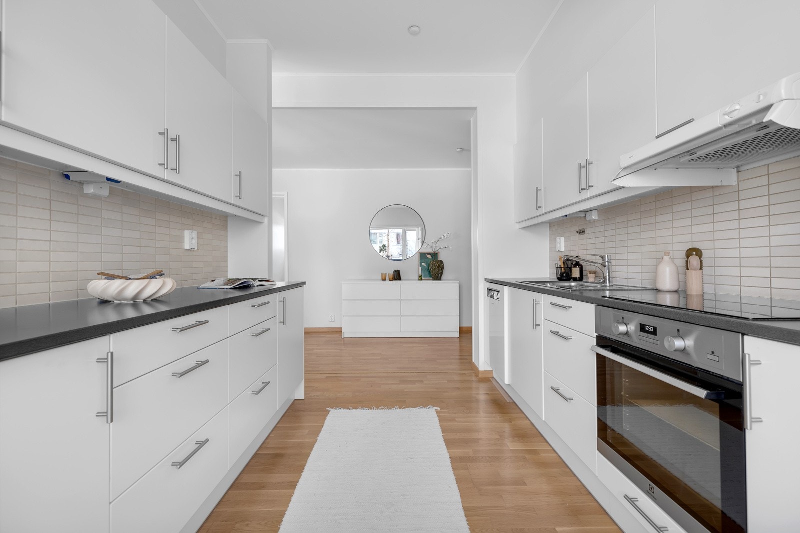 Kjøkkenet er praktisk og pent. Hvite slette fronter, integrerte hvitevarer og god skap- og benkeplass Galleribilde