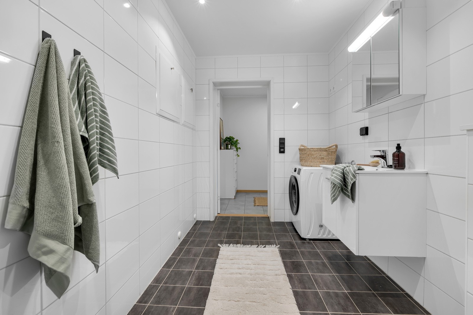 Opplegg for vaskemaskin og tørketrommel, vegghenht toalett, innfelt belysning i tak og innfellbare glassdører i dusjsonen Galleribilde