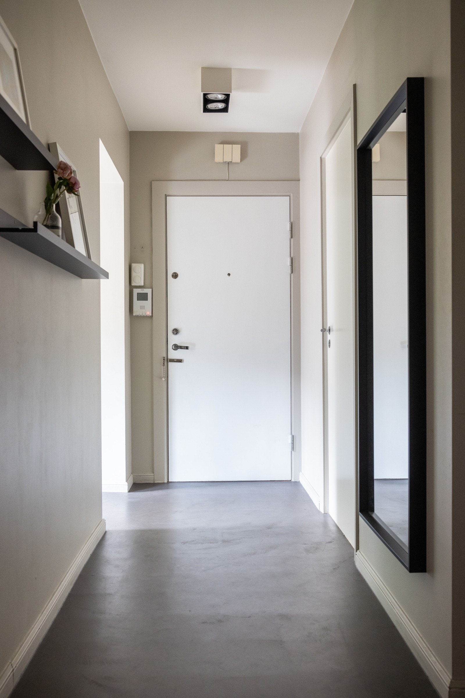 Velkommen inn! Man ankommer leiligheten i en innbydende entré med lyse overflater og microsement på gulv. Galleribilde