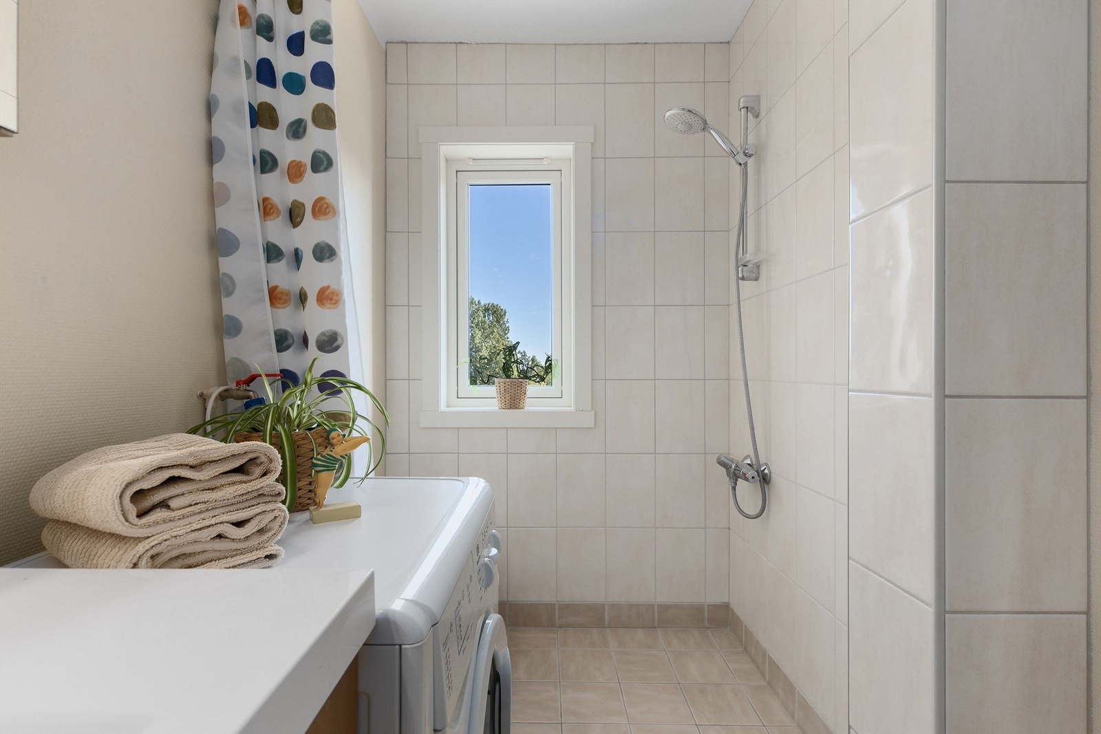 Videre er badet innredet med servantskap med overskap og speil med lys samt dusjhjørne. Galleribilde