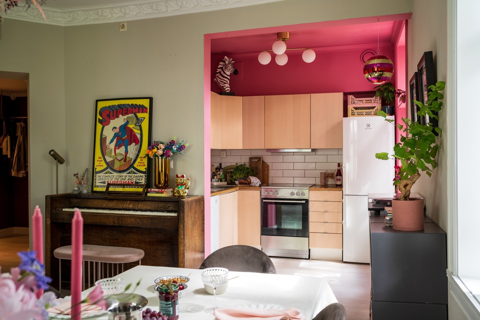 Kjøkkeninnredning med finerte fronter, laminat benkeplater, oppvaskkum, ventilator, fliser over benk, oppvaskmaskin, kombiskap og komfyr med keramisk platetopp. Galleribilde