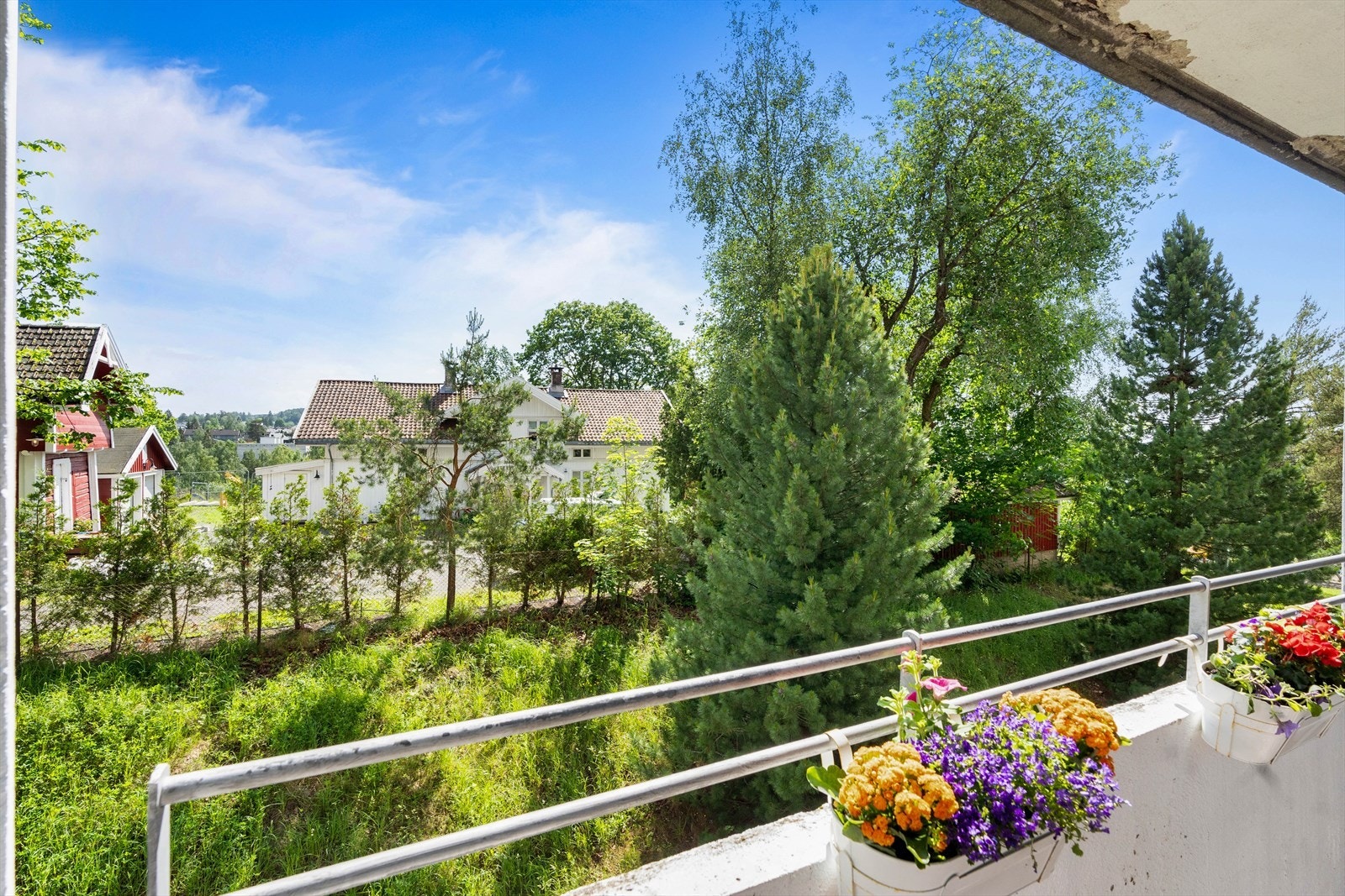 Balkongen har pent utsyn mot nabolaget, som er bestående av vegetasjon og trær. Galleribilde