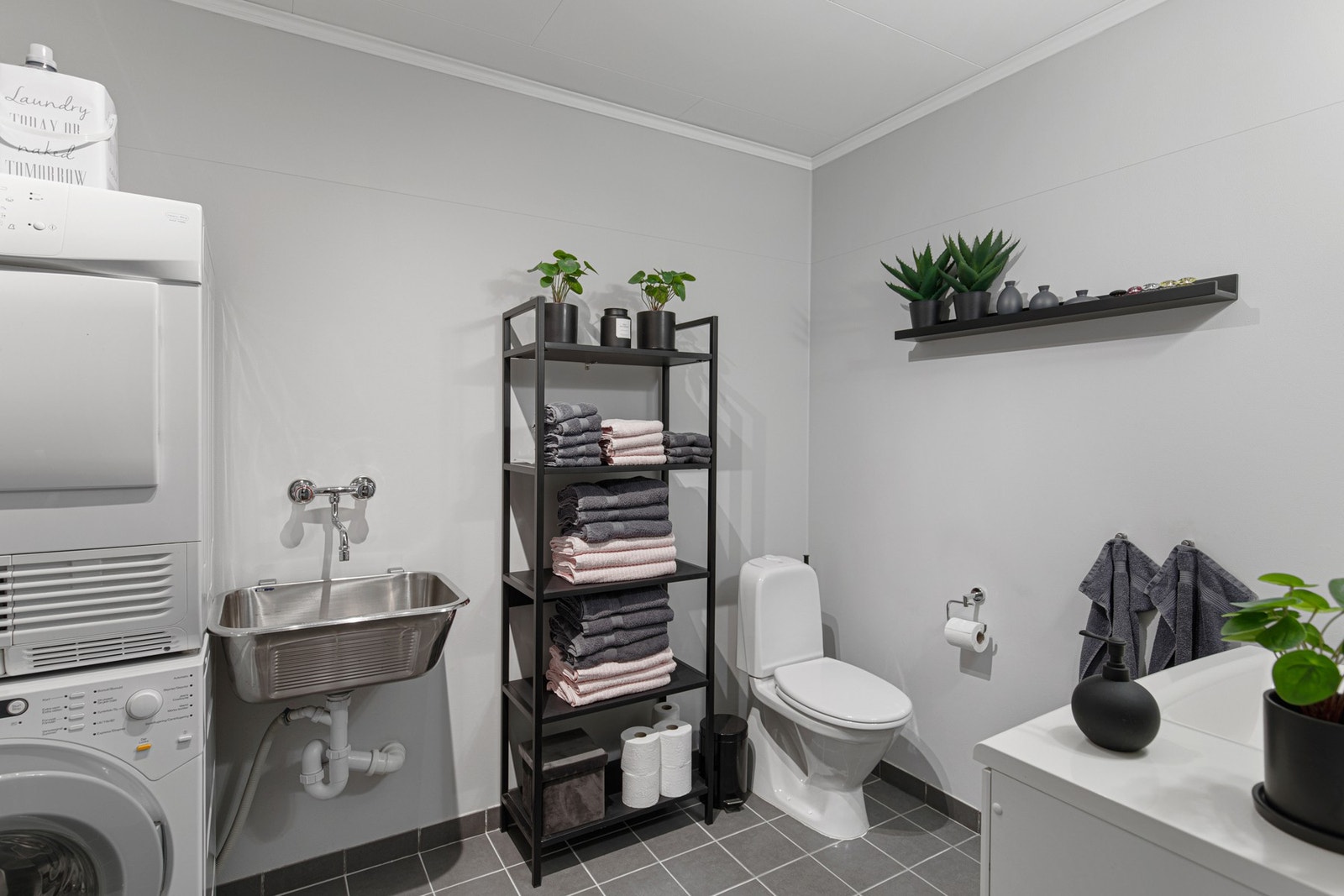 Leilighetens bad har flislagt gulv og våtromstapet på vegger. Galleribilde