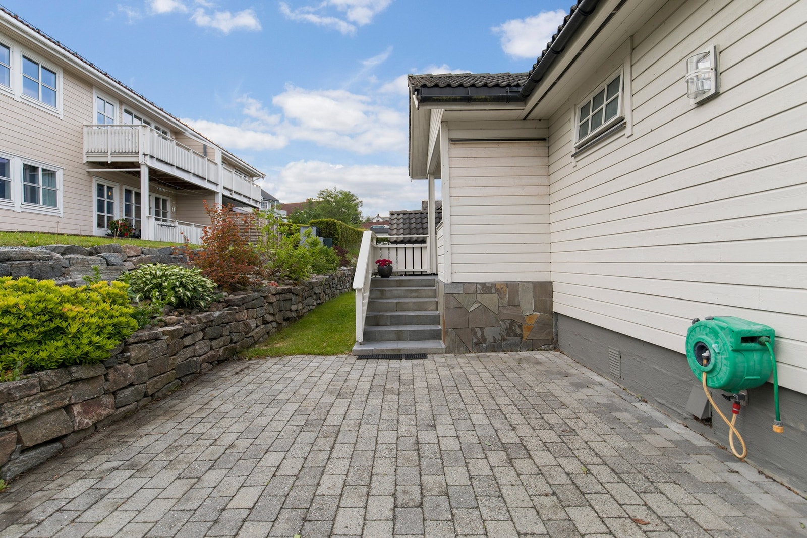 Hovedetasjens inngangsparti har tilkomst via gangvei med belegningsstein. Galleribilde